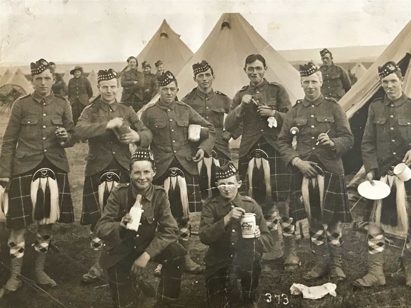 Joseph French (front left) kneeling and holding a pint of milk.
