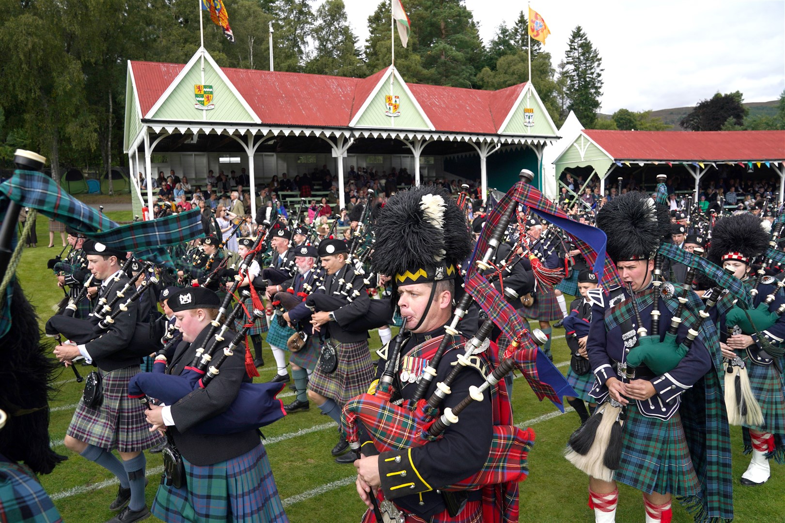 Pipe bands march in front of the pavilion ahead of the arrival of members of the royal family (Andrew Milligan/PA)