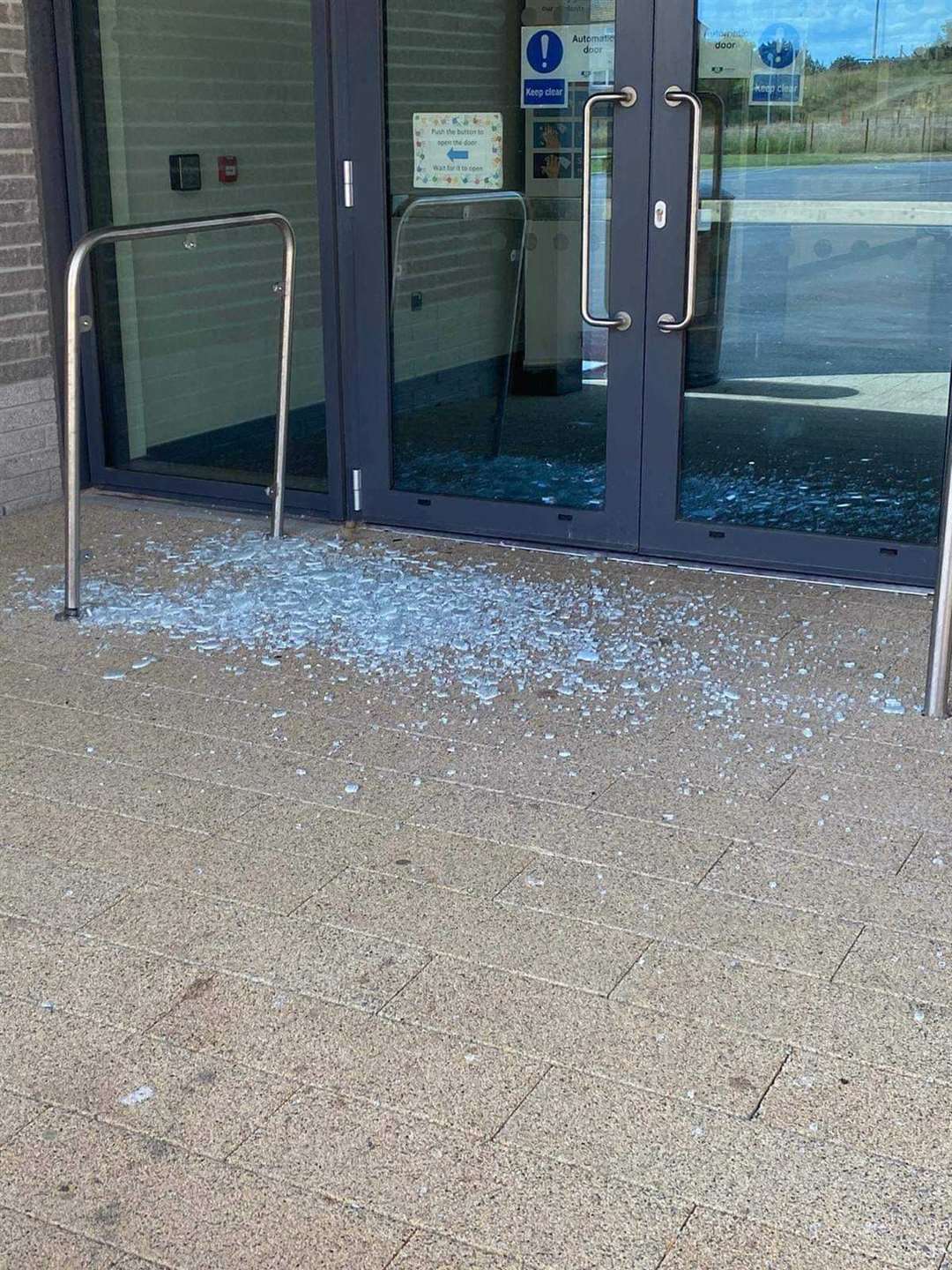 Glass strewn on the ground after vandals smashed a door at Lossiemouth's new high school.