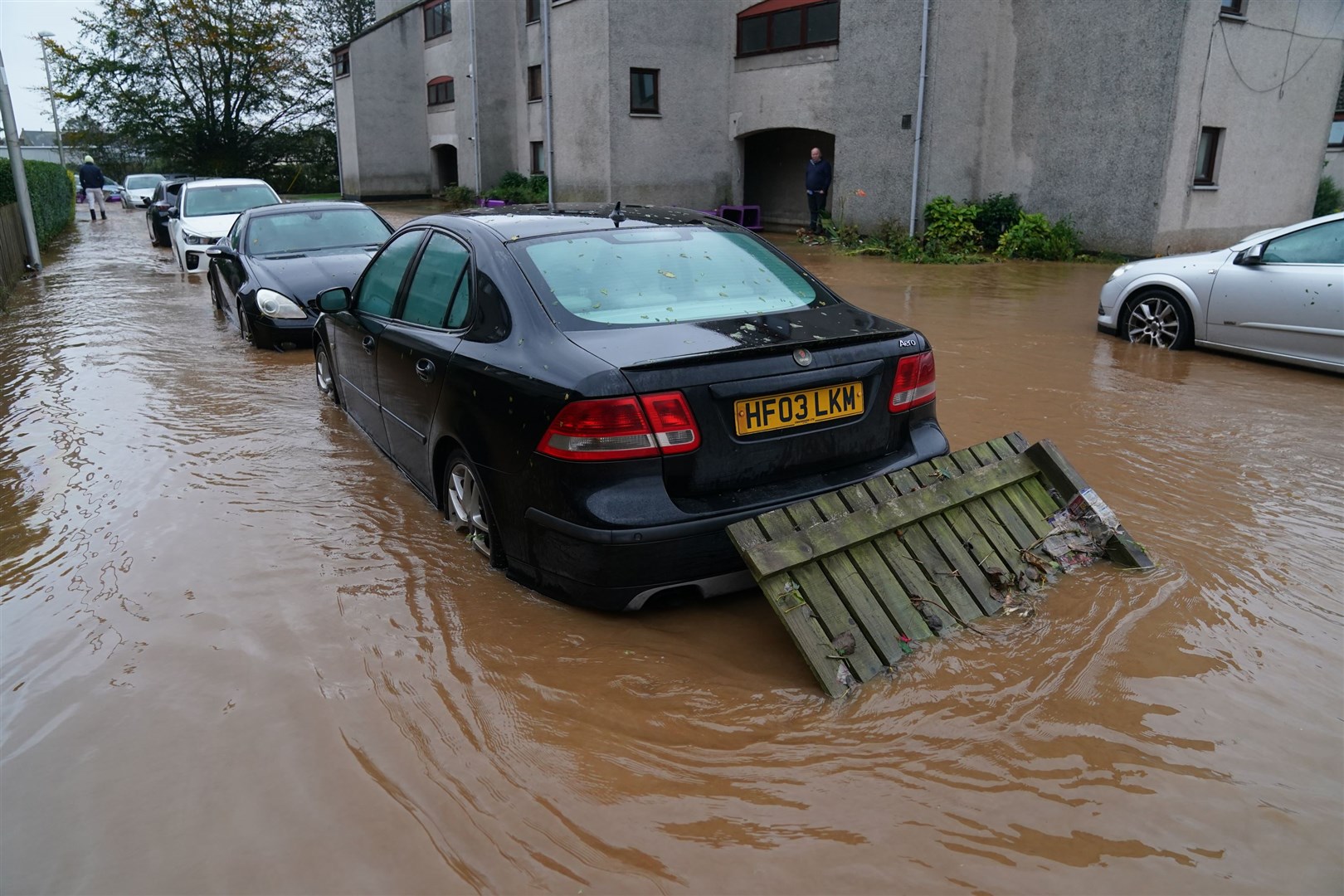 A fence panel washed away by floodwater rests against a car in Brechin during Storm Babet (Andrew Milligan/PA)