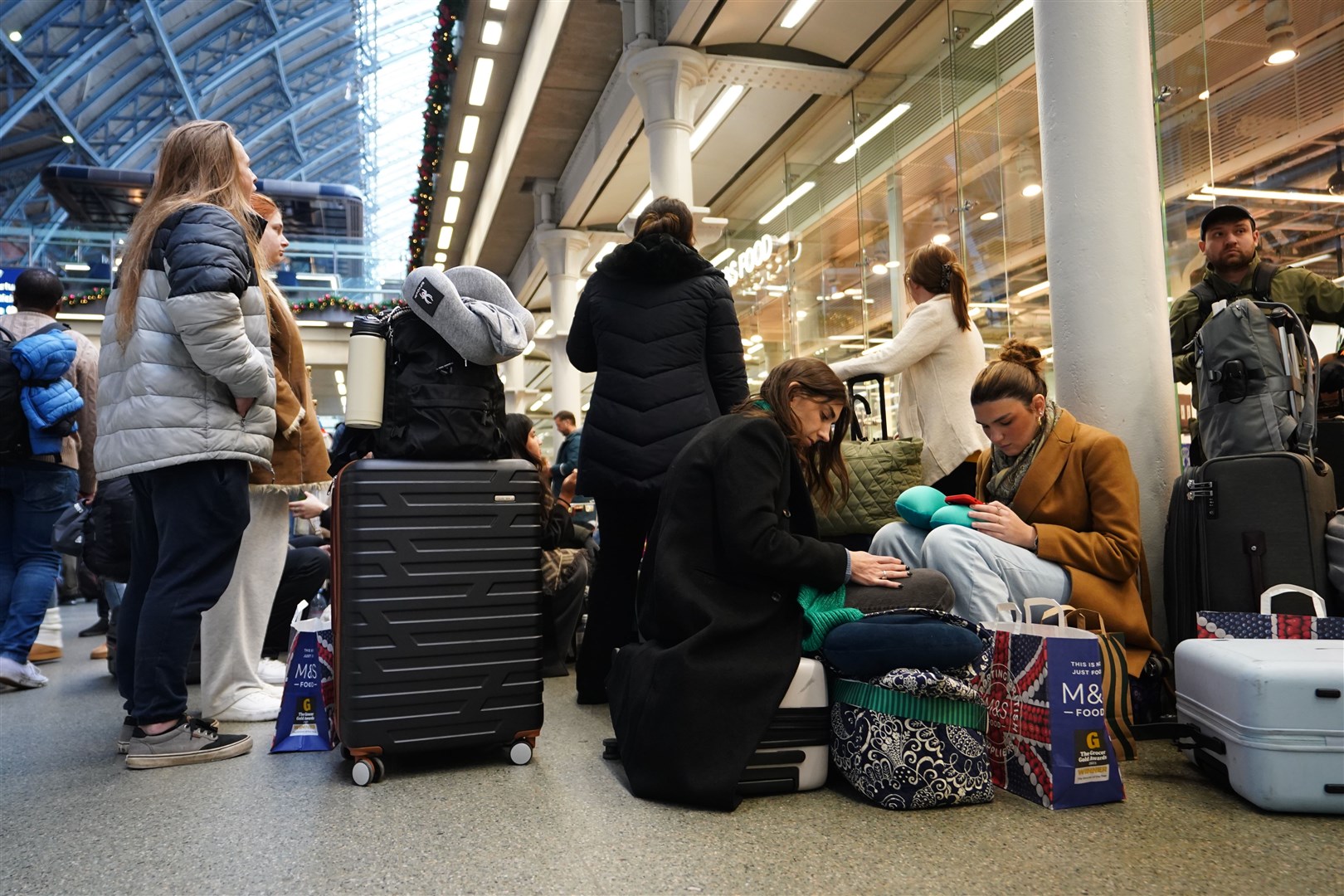 Passengers sit on the floor of the concourse at St Pancras International (James Manning/PA)