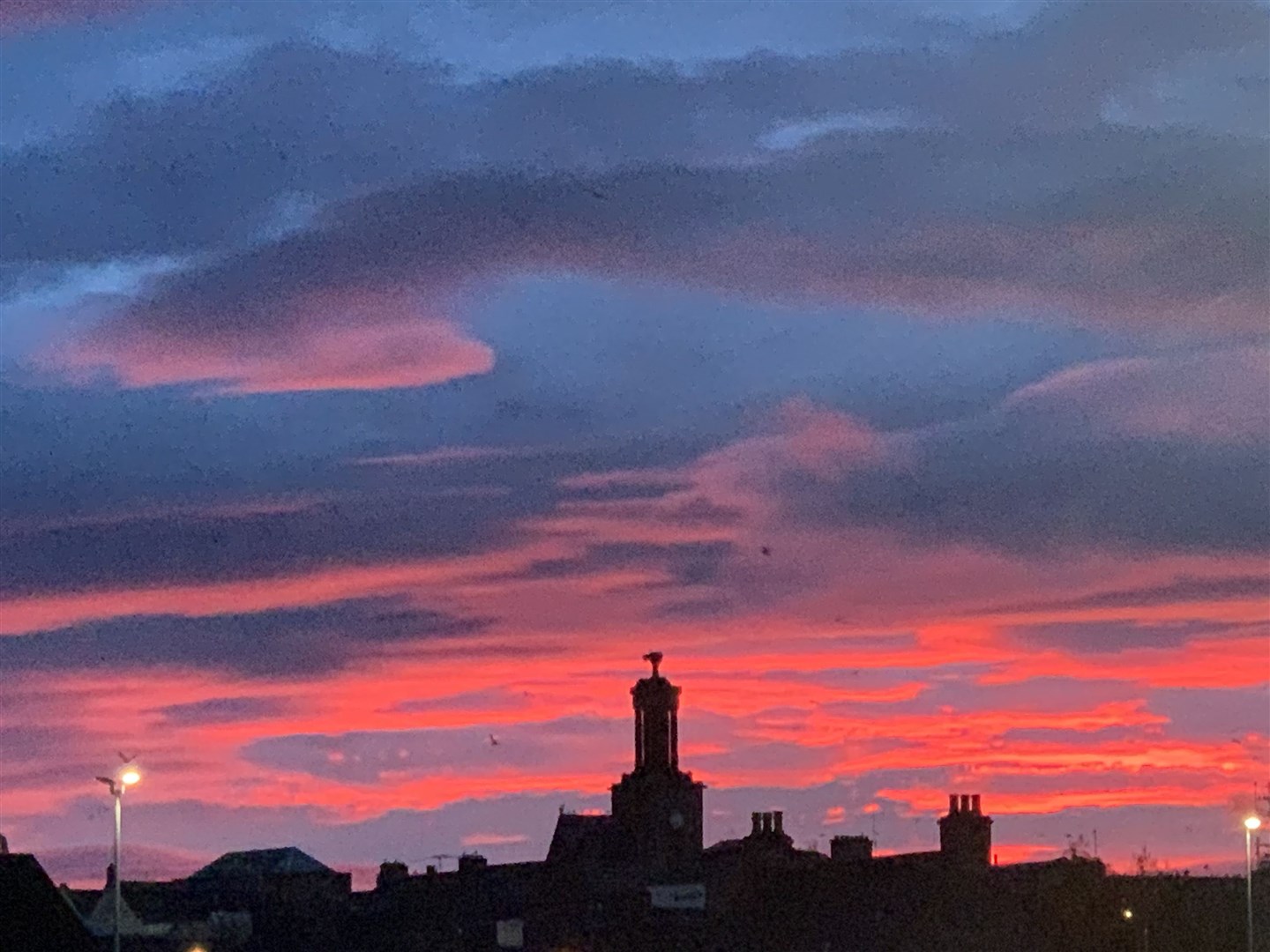 The sky is lit up red over the centre of Elgin.
