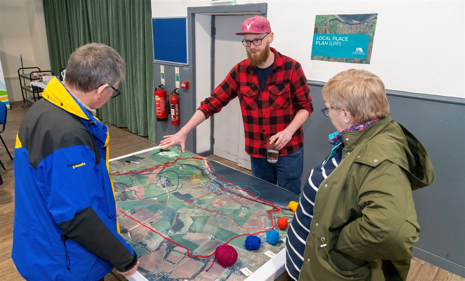 PCT director Drew Ewen (centre), shows the Portgordon Local Place Plan to members of the public. Picture: Beth Taylor