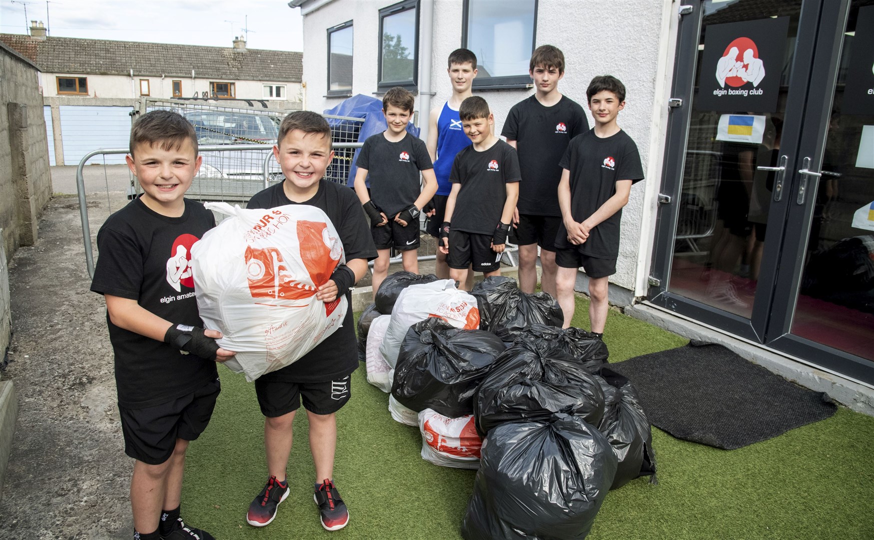 Elgin Amateur Boxing Club youngsters, from left: Charlie and Brodie Pirie, Hewie More, Jonny Heffernan and Findlay Gardiner with Tyler Sked (back left) and Levi Gardiner (back right) help to organise around 30 bags of items to be sent out to war-torn Ukraine...Picture: Becky Saunderson..