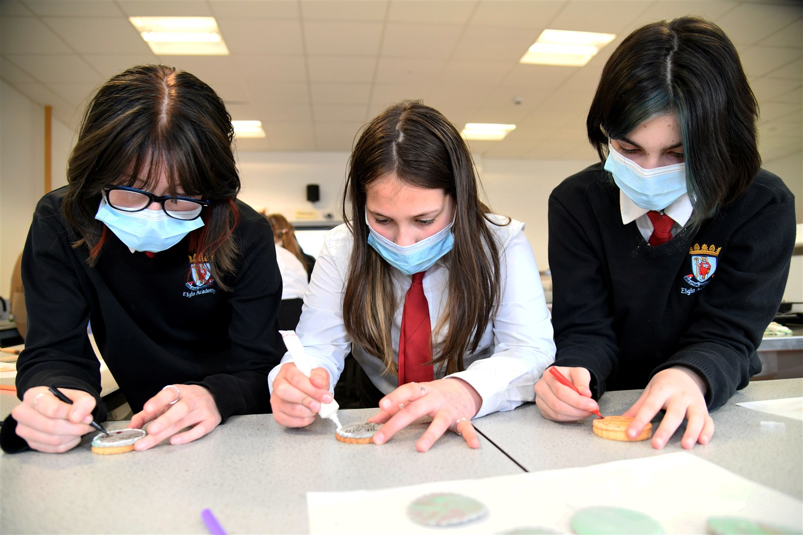 From left: Kylah Varney, Carmen Smith-Hind, Caitlyn Hicks decorate biscuits. World Book Day at Elgin Academy. Picture: Becky Saunderson