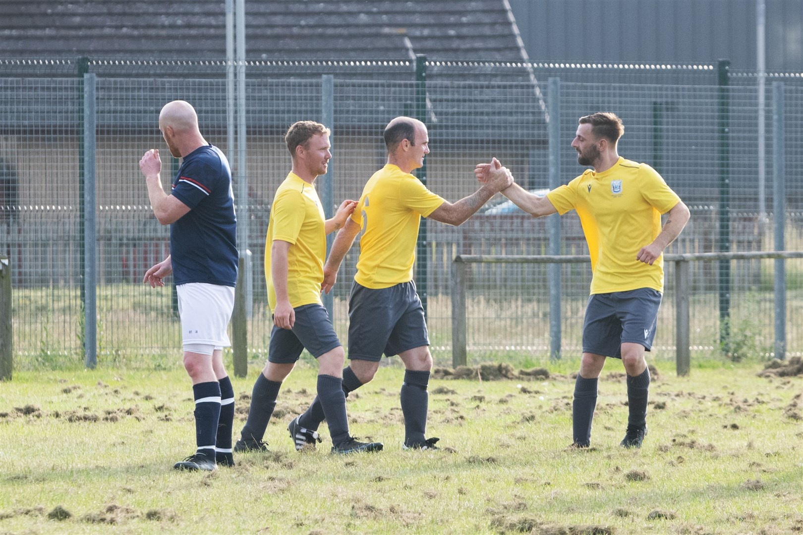 Gary Burr (centre) celebrates a goal earlier in the season. The combative midfielder is a key figure for Hopeman.