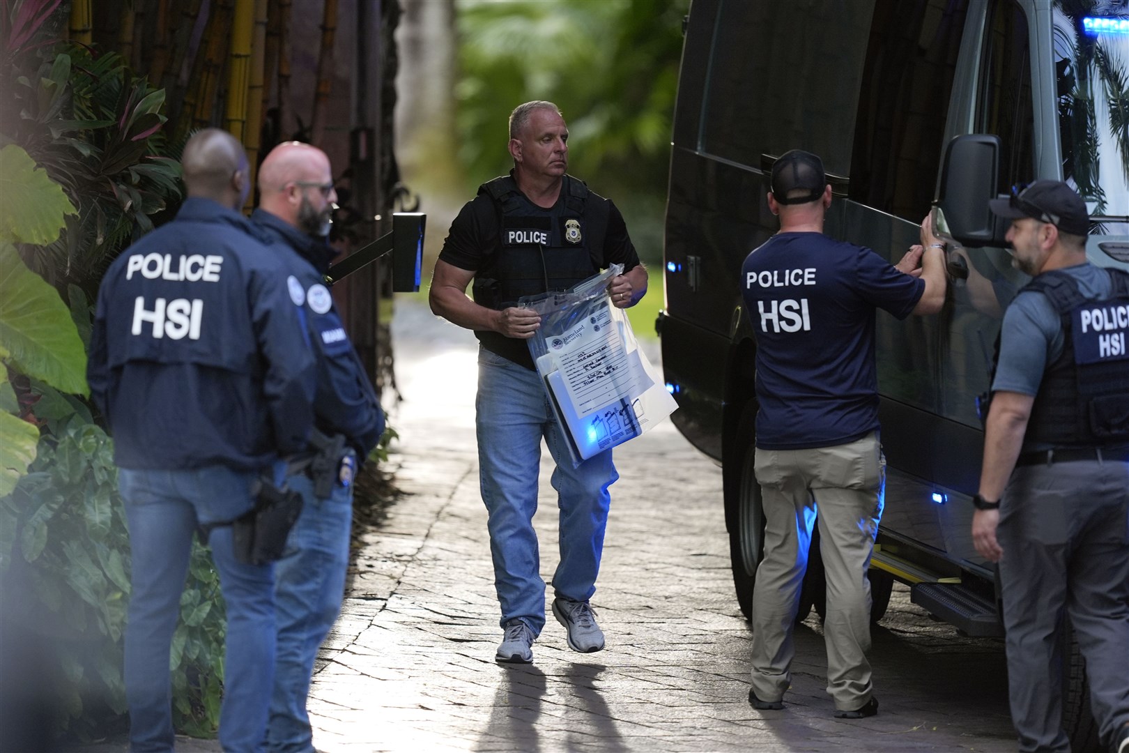 A law enforcement agent carries a bag of evidence to a van as federal agents stand at the entrance to a property belonging to rapper Sean ‘Diddy’ Combs (Rebecca Blackwell/AP/PA)