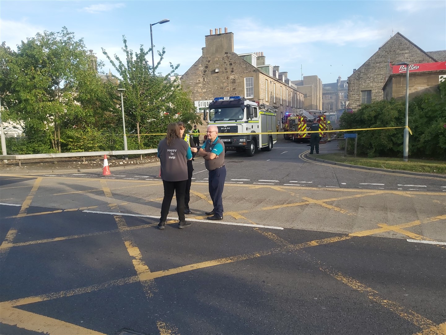 Poundland manager Gerry McAloon and another staff member talk to a police officer at the scene. Picture: Highland News and Media