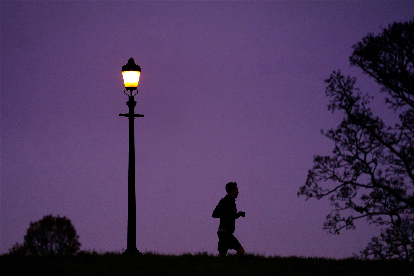 A man jogging during misty weather in Primrose Hill, London, early in December (Victoria Jones/PA)