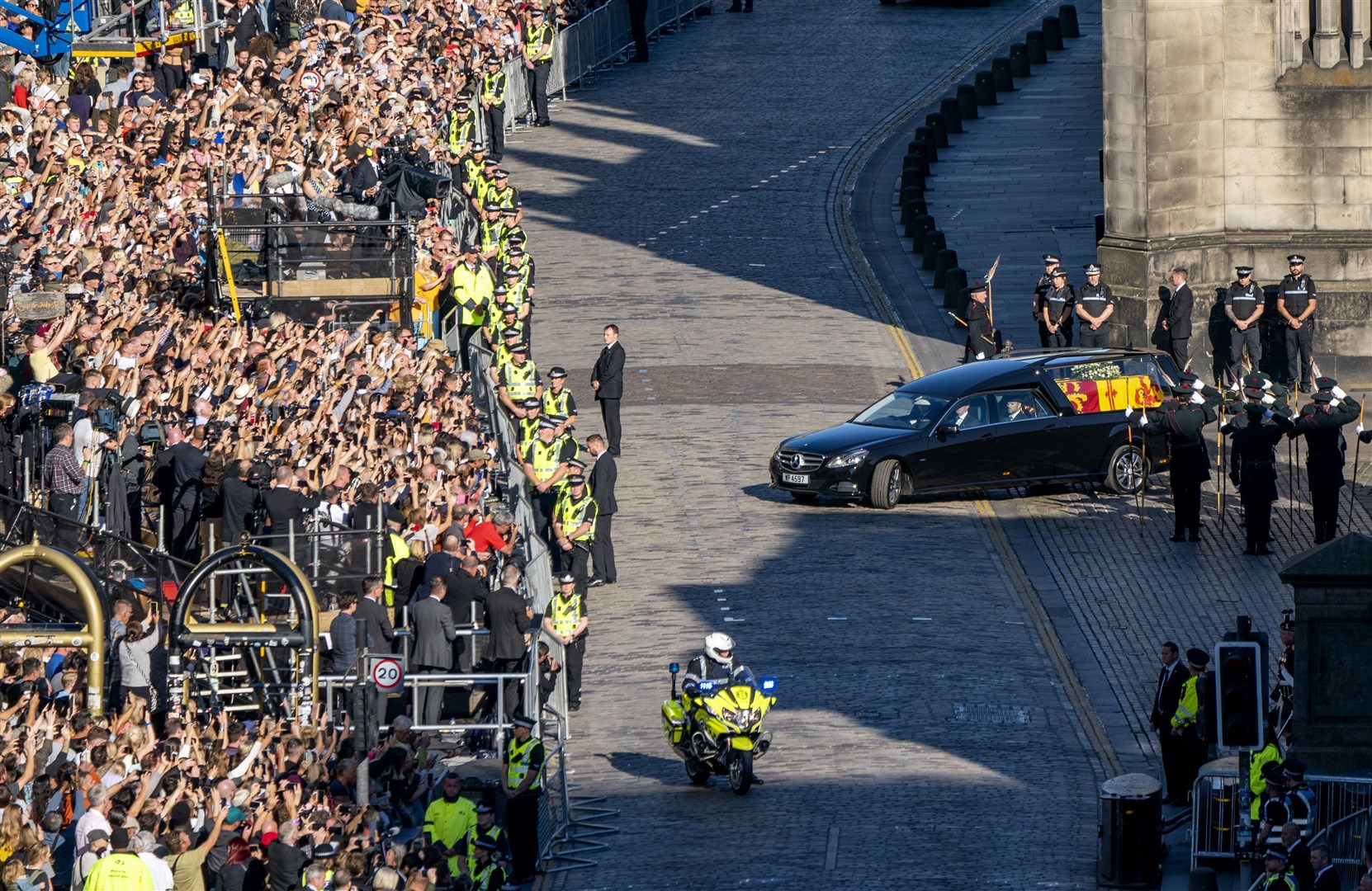 The hearse carrying the coffin of the Queen travels up the Royal Mile after departing St Giles’ Cathedral for Edinburgh Airport (Jane Barlow/PA)