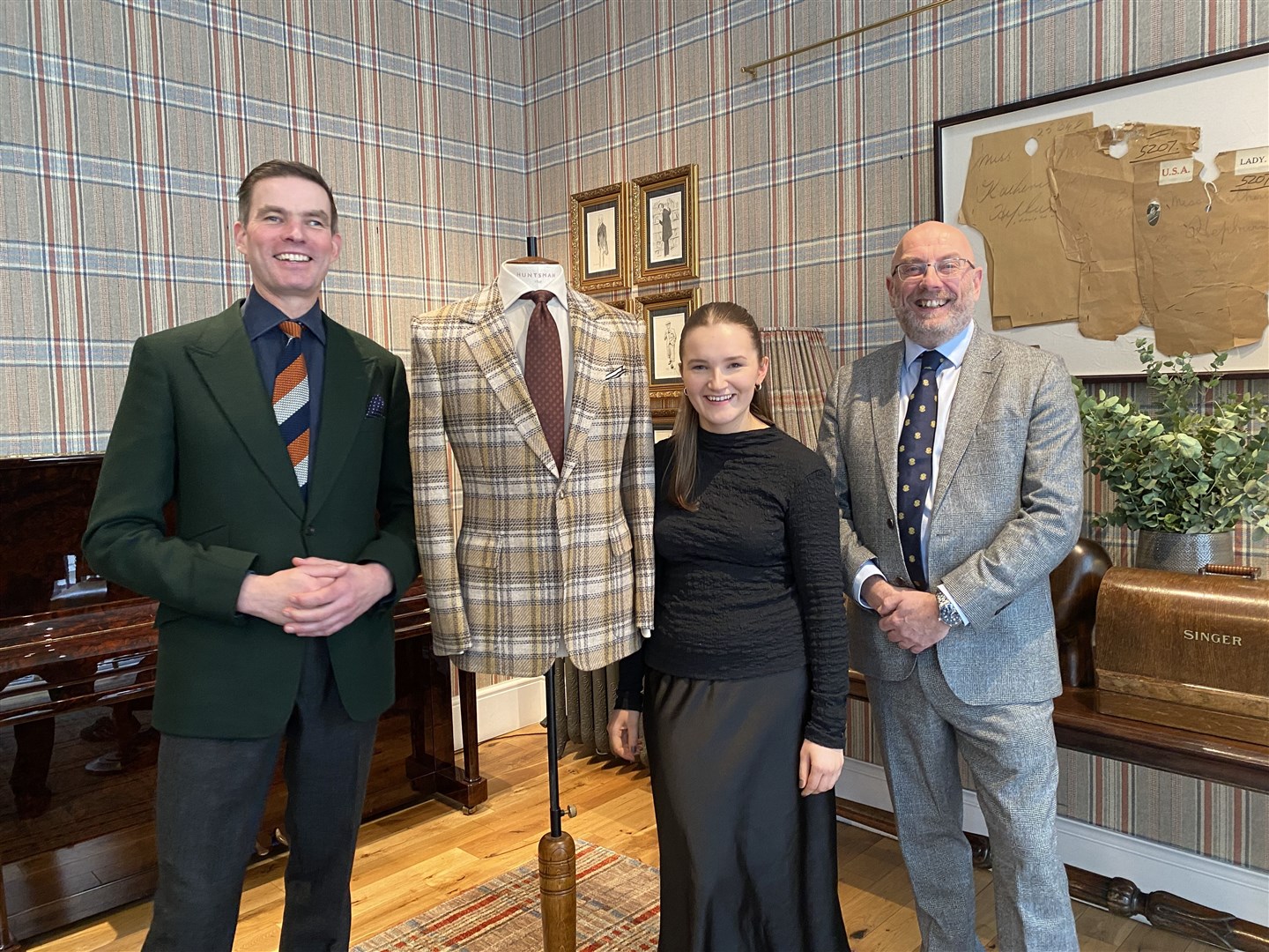 Lois Cowie admires the sports jacket made from her winning textile design, joined by Campbell Carey (left), the Head Cutter and Creative Director at Huntsman, and Iain Milligan, Managing Director of Huddersfield Fine Worsteds.
