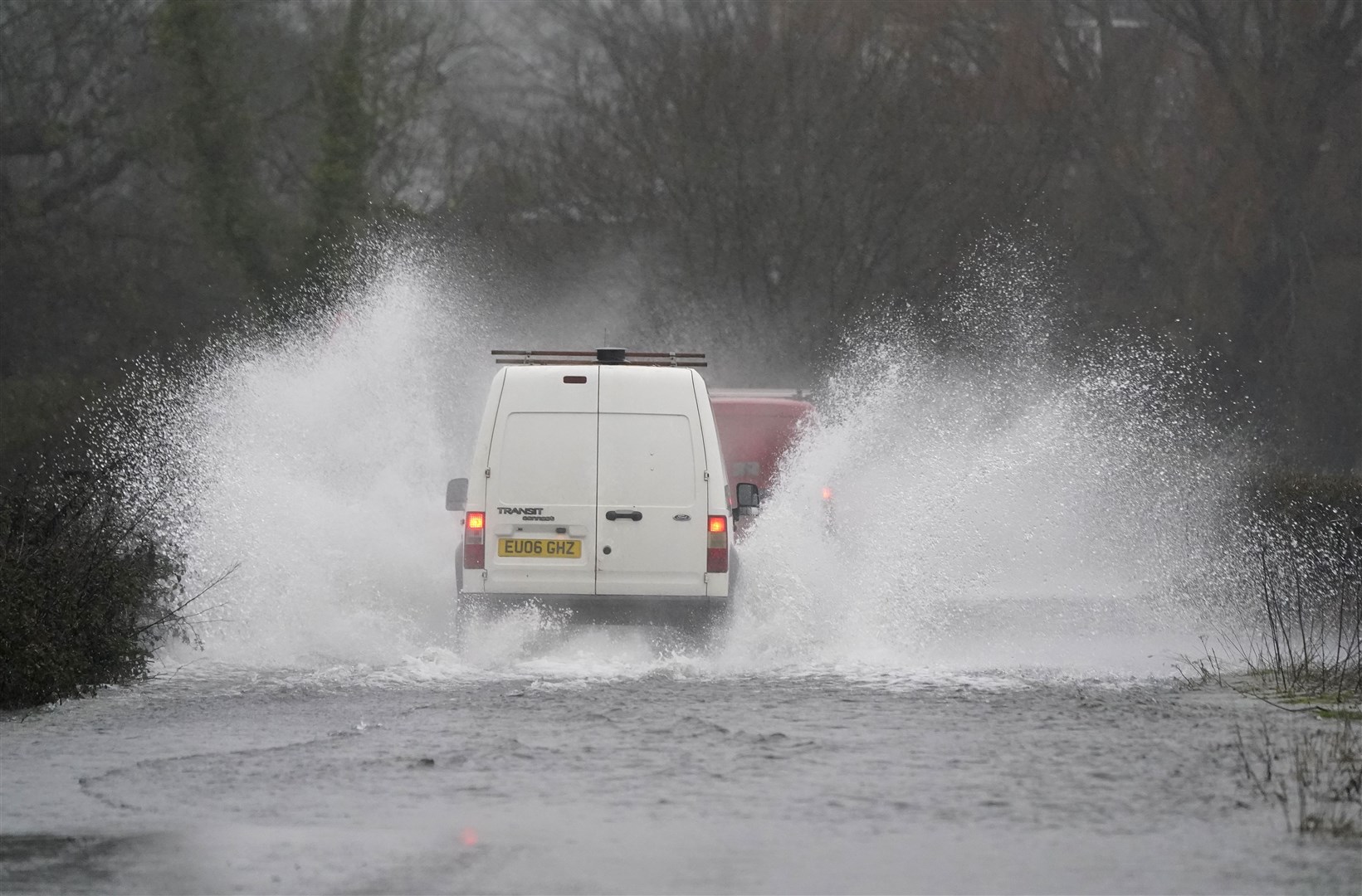 Cars make their way through flood water on Kent Lane, near to Ibsley (Andrew Matthews/PA).