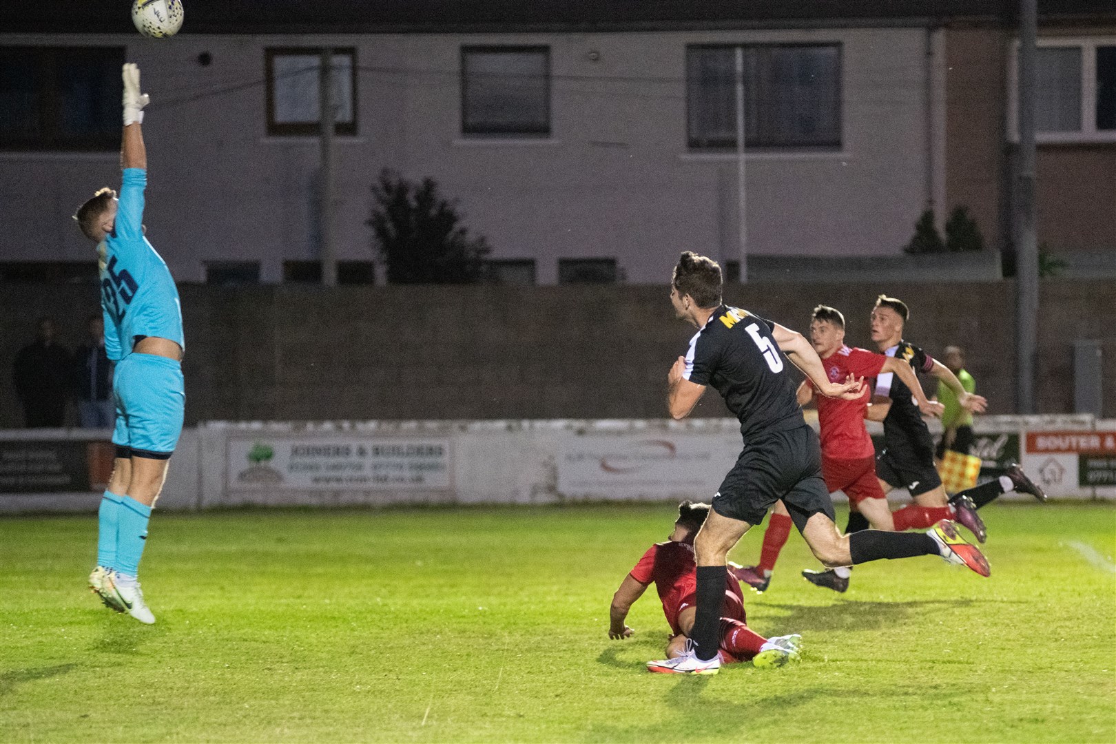 Strathspey #5 Stephen Kelly flicks the ball over Lossie's Ross Elliott and his own keeper towards goal for the home side's third...Lossiemouth FC (4) vs Strathspey Thistle (2) - Highland Football League 22/23 - Grant Park, Lossiemouth 24/08/2022...Picture: Daniel Forsyth..