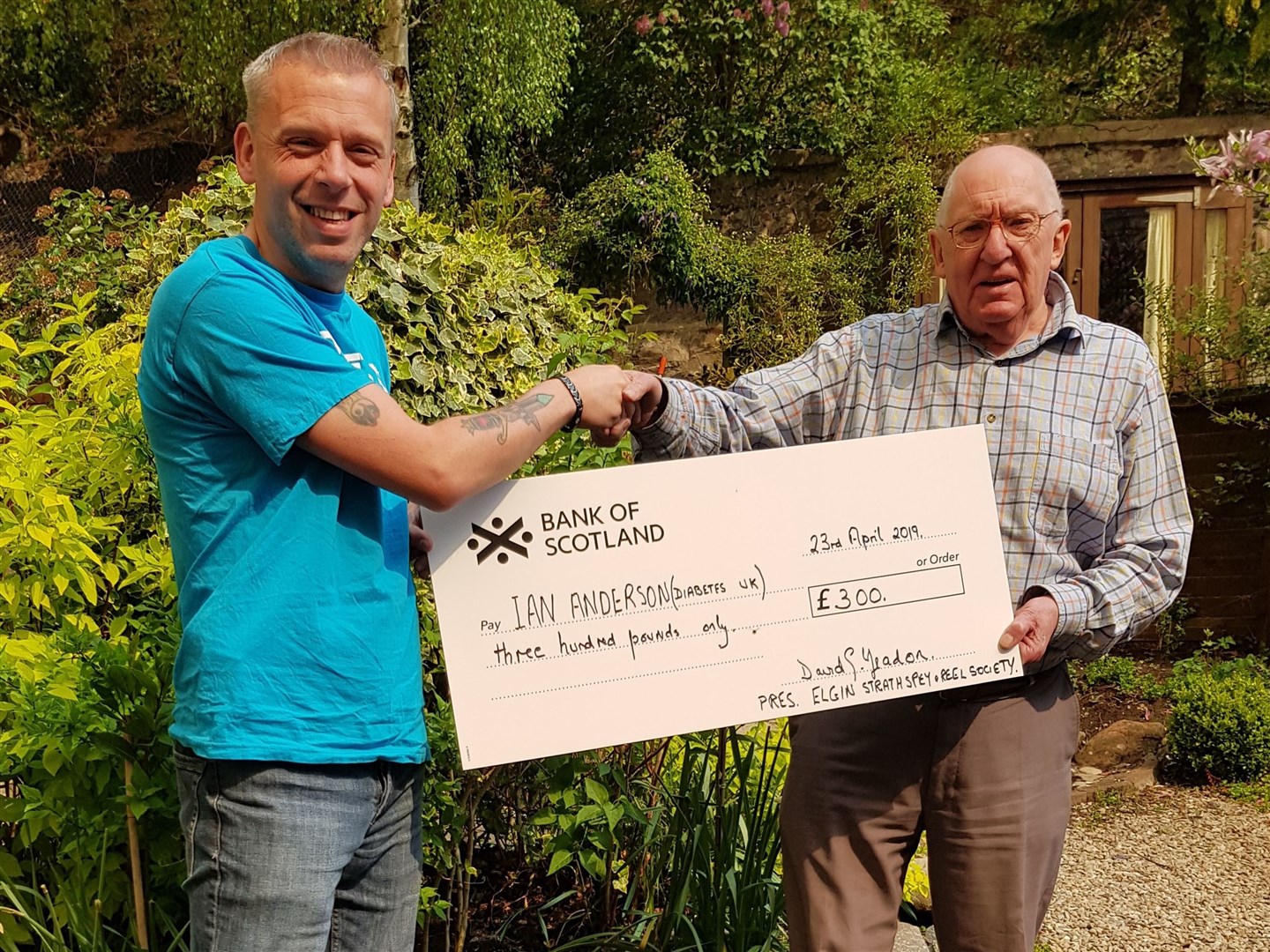 Chairman of Elgin Strathspey and Reel Society David Yeadon presents Ian Anderson with a cheque for £300.