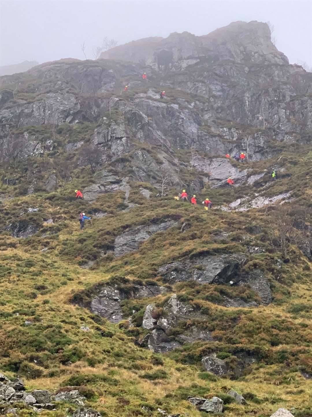 Mountain rescue teams scale a peak to reach a casualty.