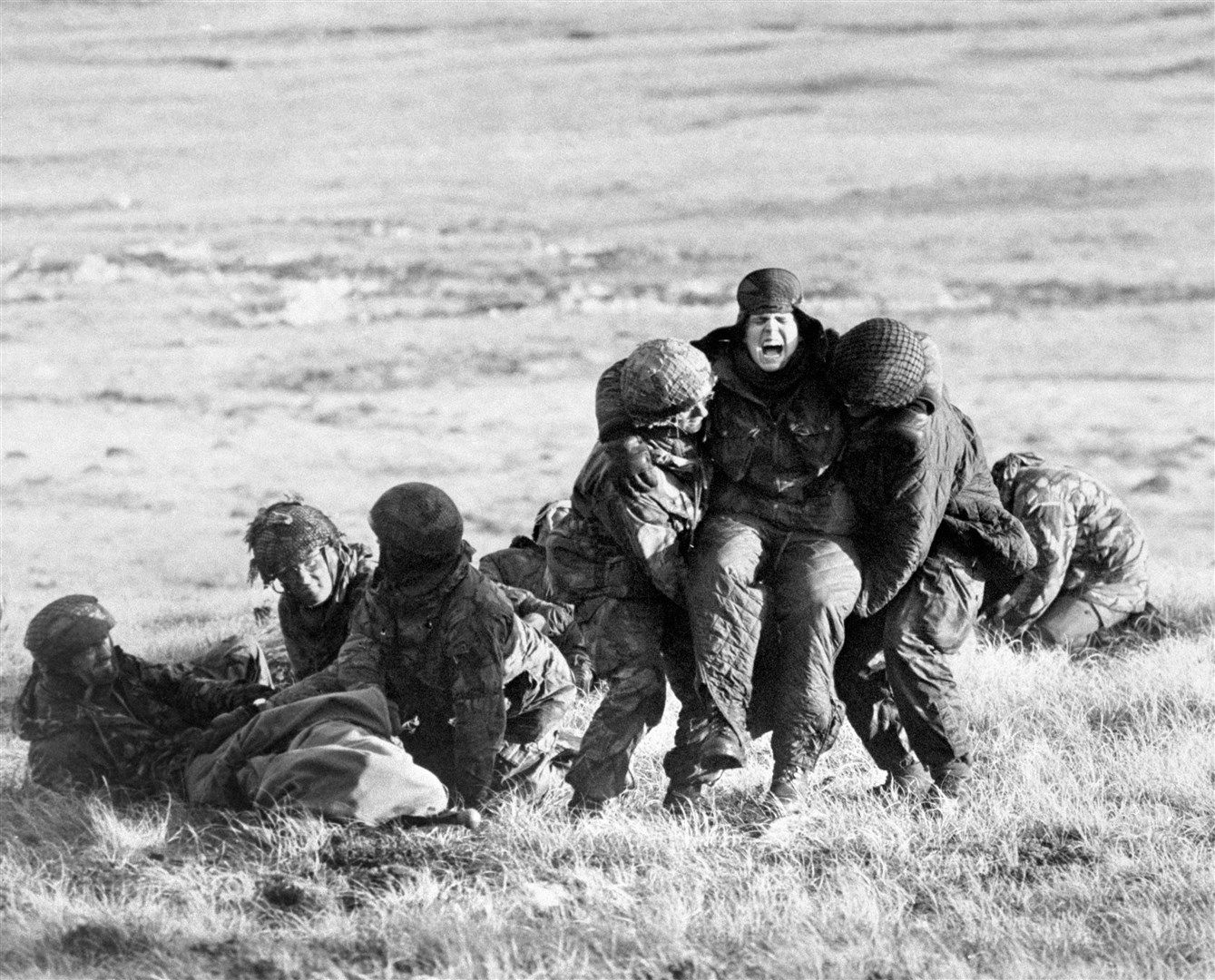 British paratroopers treating wounded comrades while under fire on Mount Longdon during the Falklands campaign (PA)