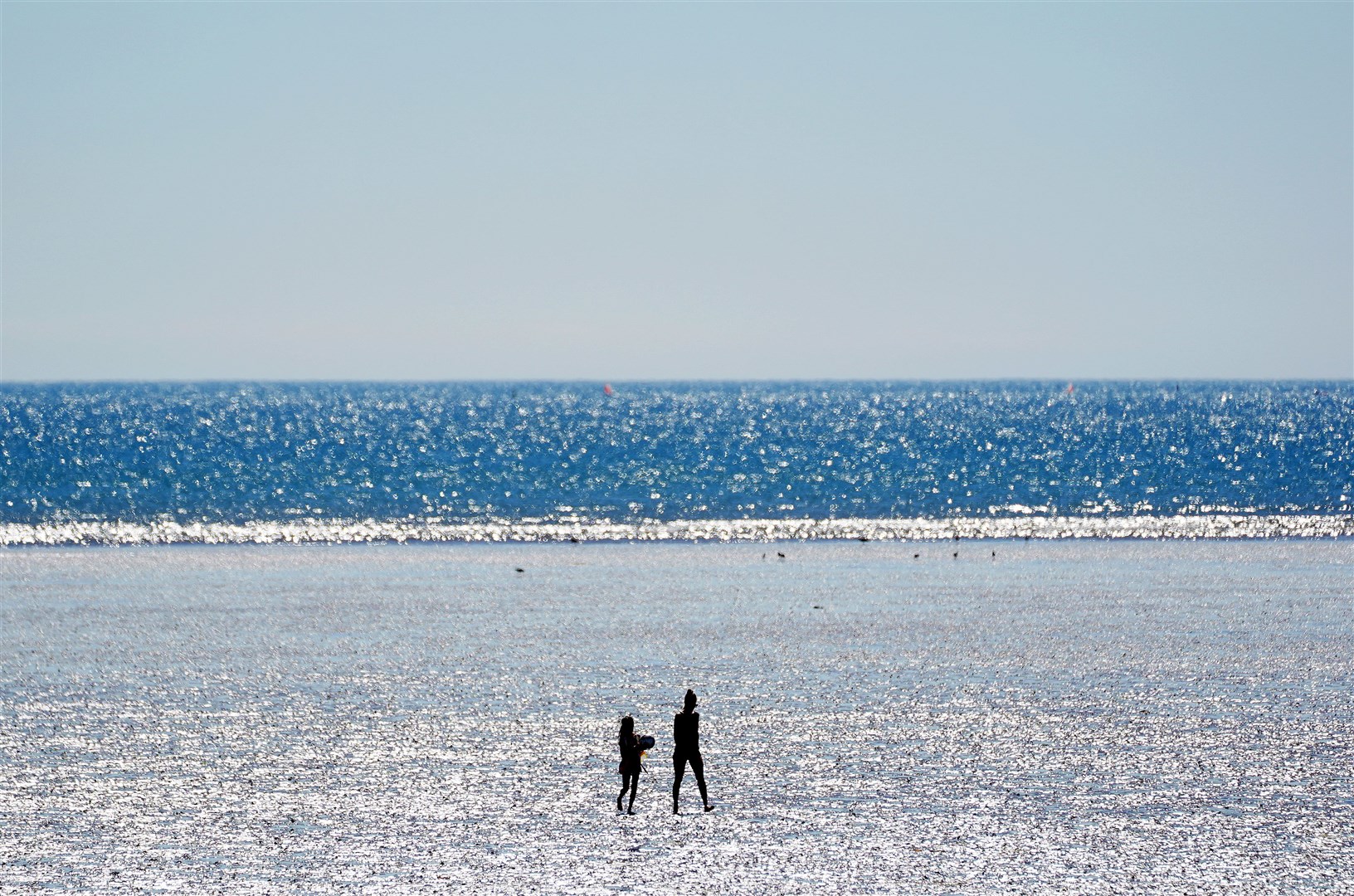 People walk on Dollymount Strand in Dublin as some parts of the country reached 33C (Brian Lawless/PA)