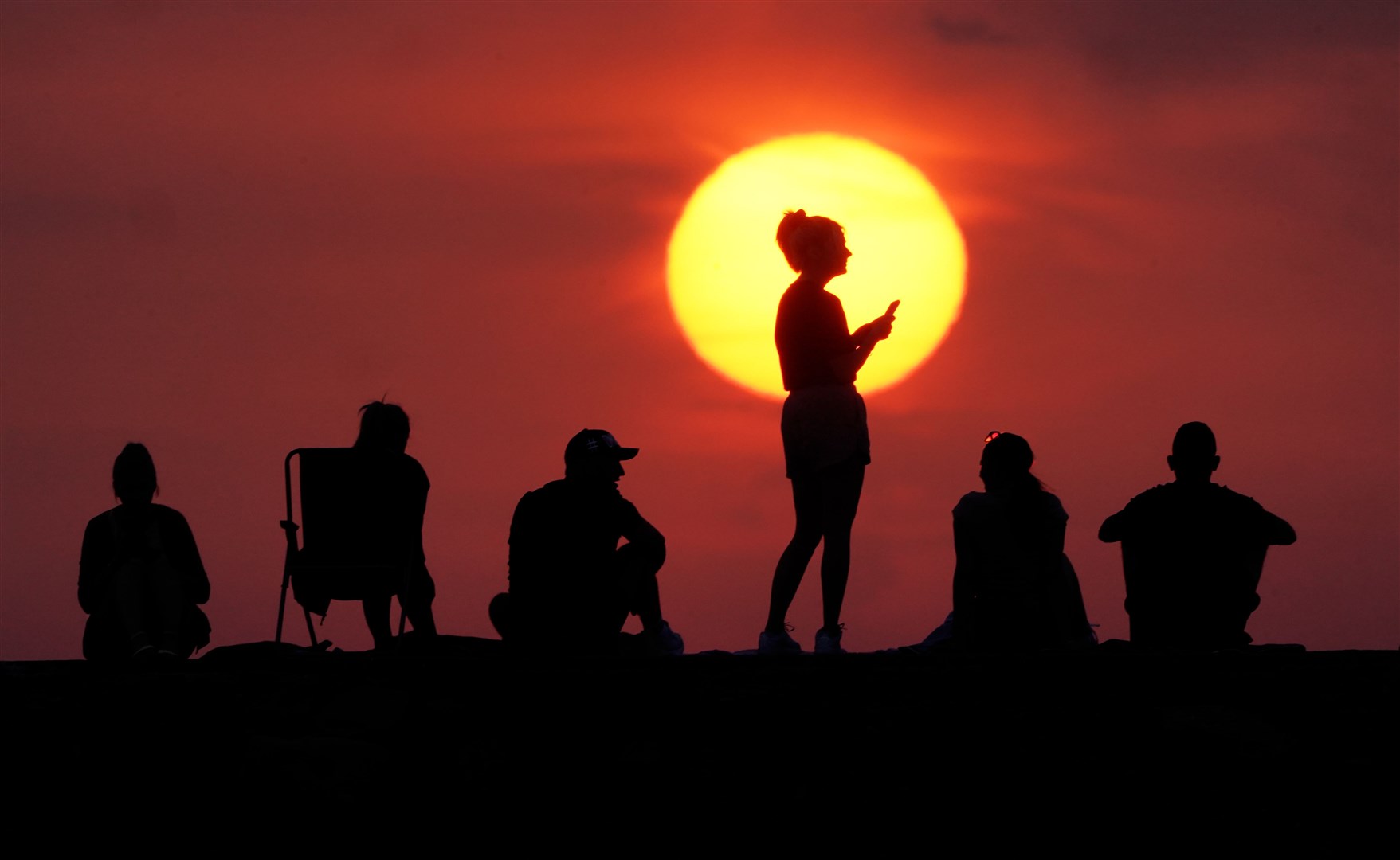 People turn out to watch the sunrise at Cullercoats Bay, North Tyneside in July (Owen Humphreys/PA)