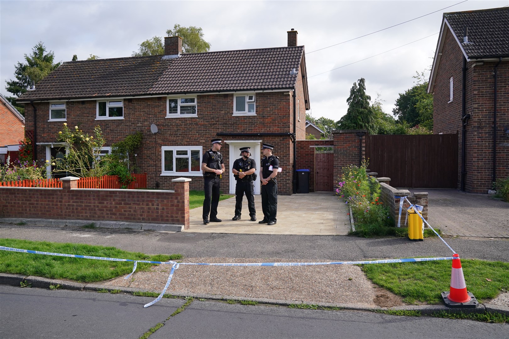 Surrey Police officers outside a property on Hammond Road in Woking (Jonathan Brady/PA)