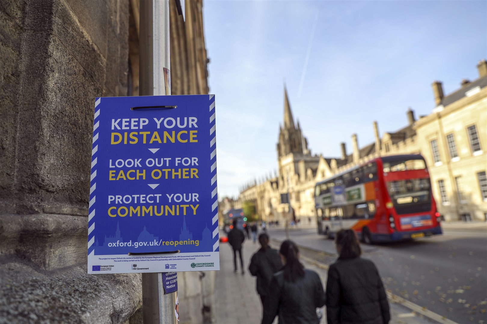 Students walk past a Covid-19 sign in Oxford (Steve Parsons/PA)