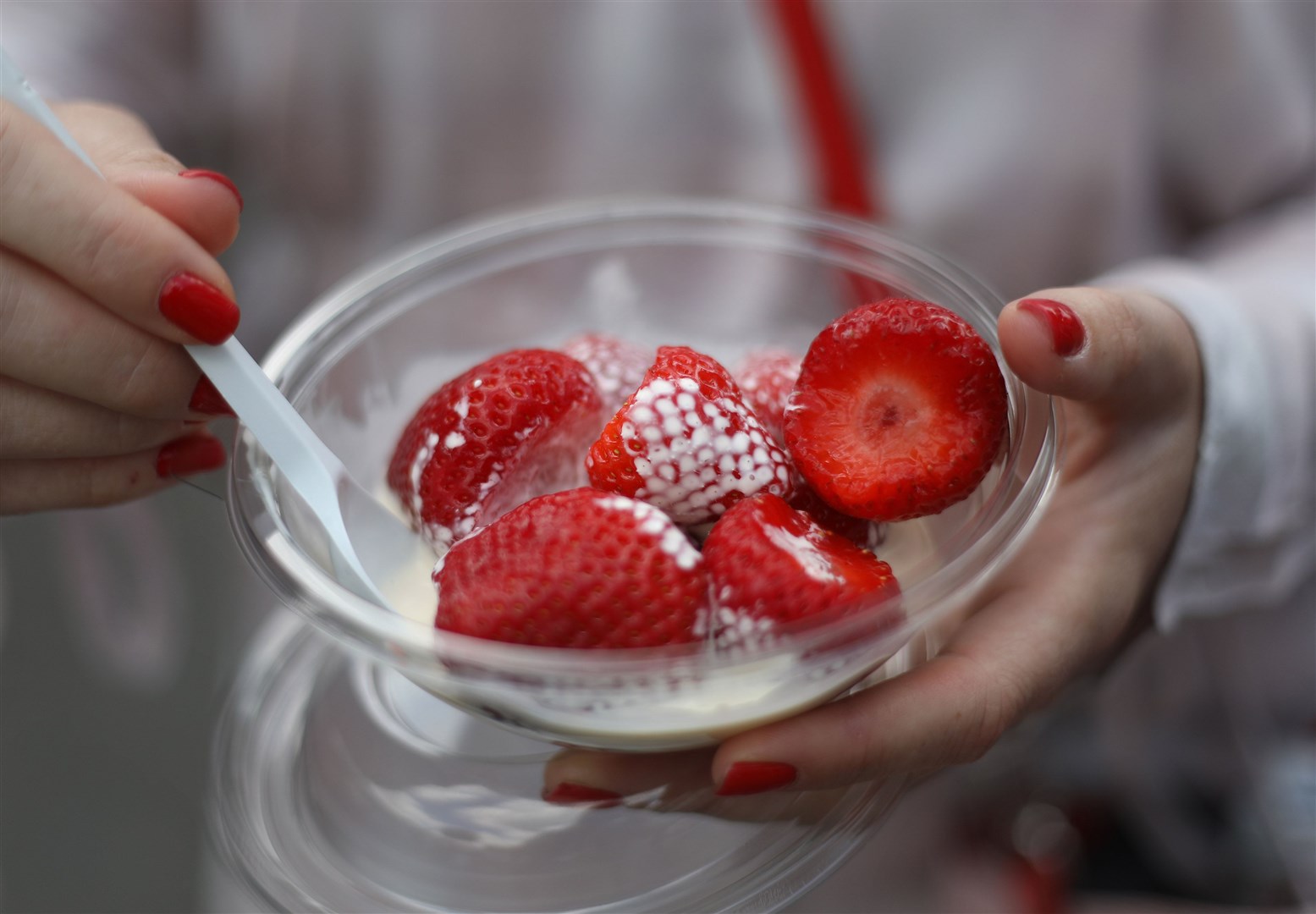 A visitor enjoys a bowl of strawberries and cream at the Wimbledon Championships (Philip Toscano/PA)