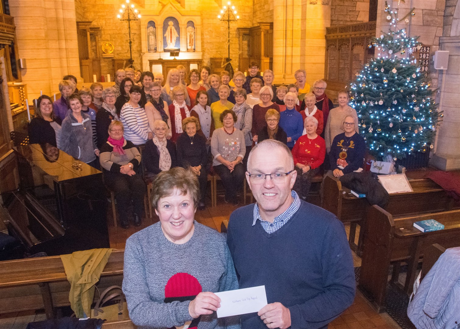 Sheena Ledingham from Cantare Choir presents a cheque for Â£1400 to Chris Saunderson from The Northern Scot Toy and Food Appeal...Picture: Becky Saunderson..