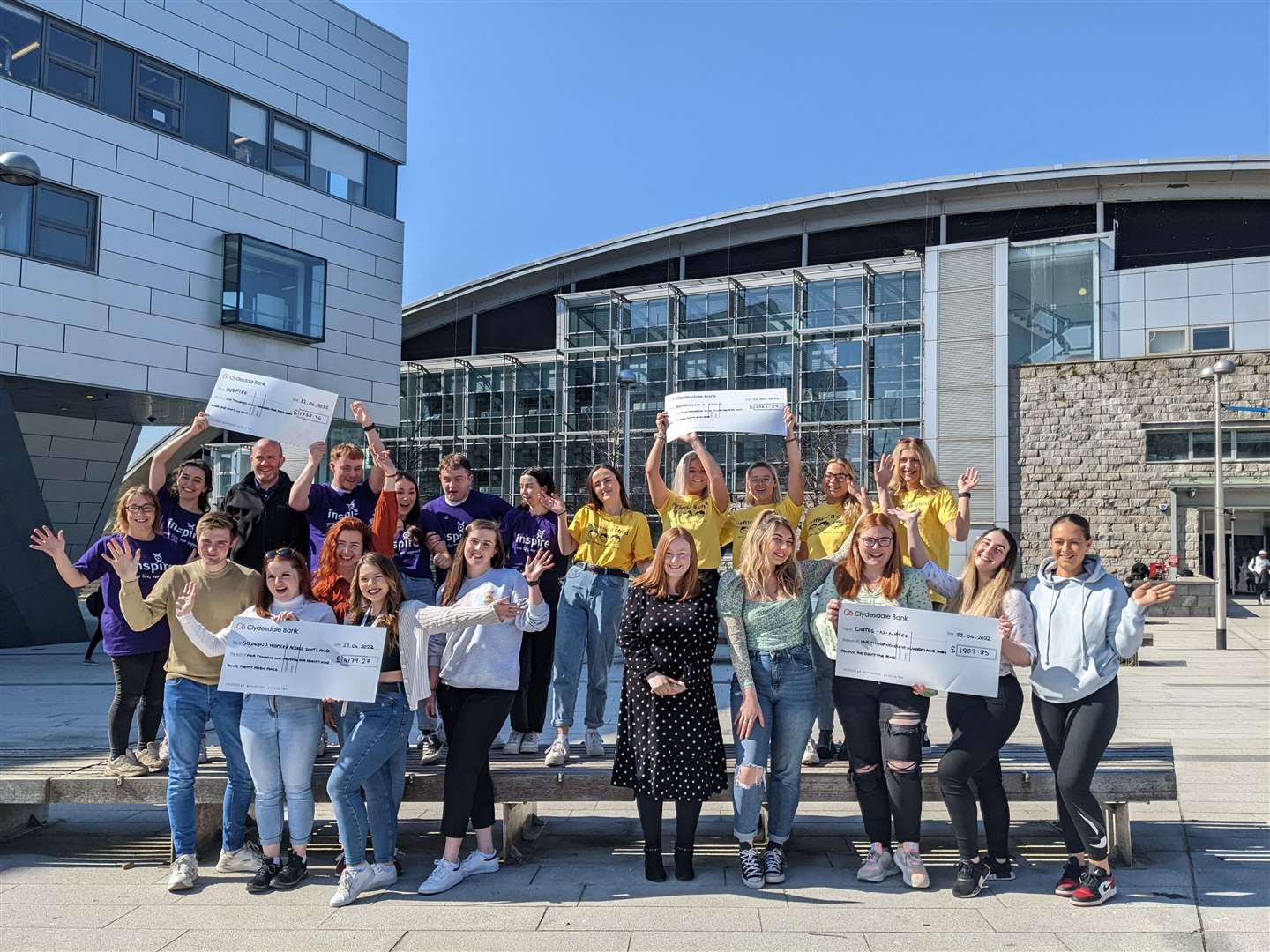 RGU Event Management students present cheques to local charities.