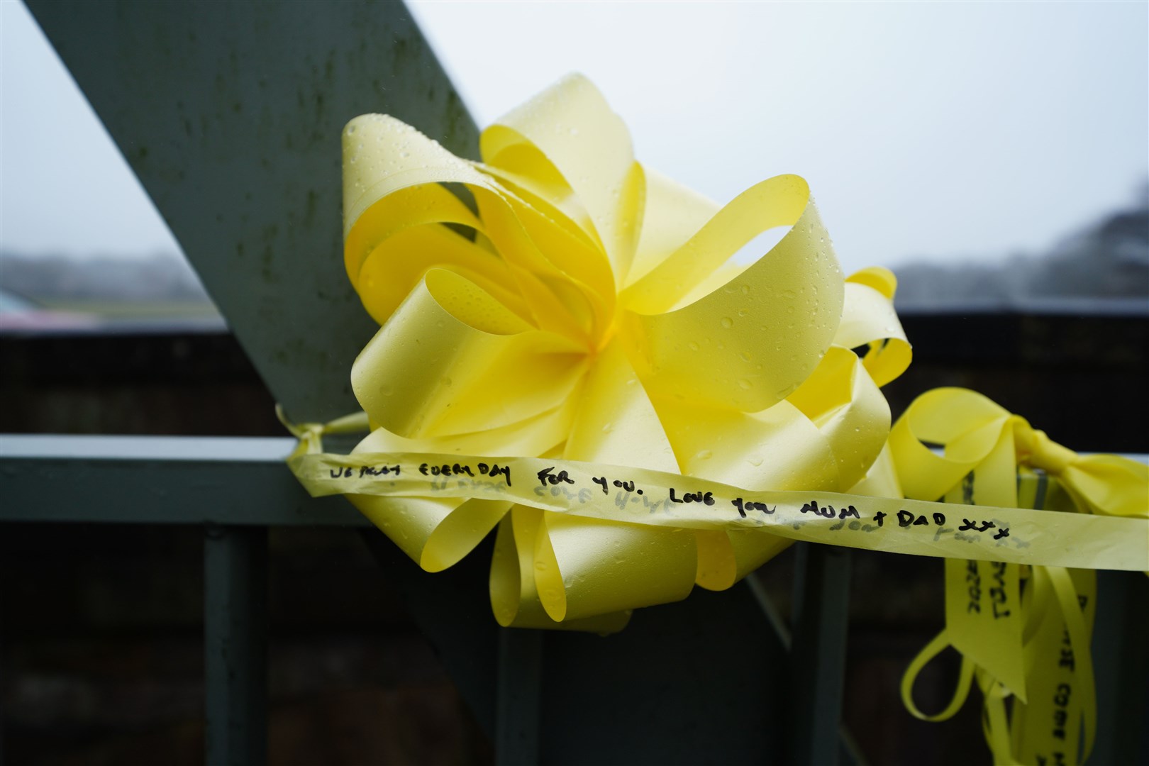 A yellow ribbon, with a message from Nicola Bulley’s parents written on it, is tied to a bridge over the River Wyre (Peter Byrne/PA)