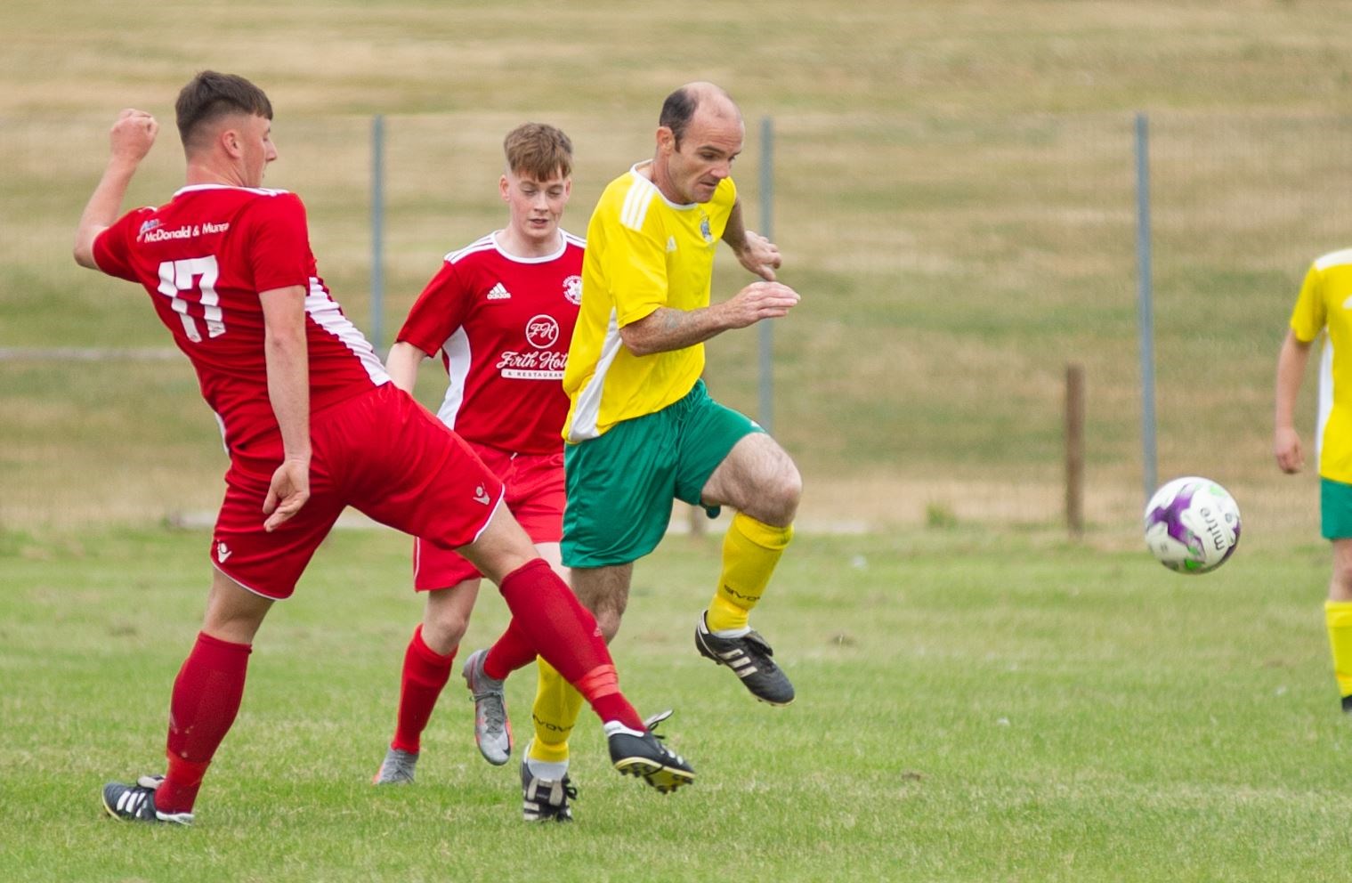 Hopeman's Gary Burr makes his way past Lossie Youths' Lewis McAndrew. Picture: Daniel Forsyth..