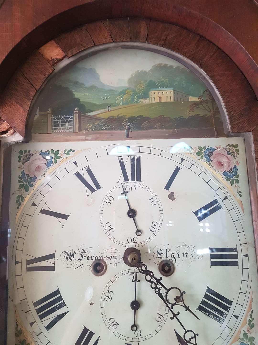 A painting of a house above the clock face remains to be identified.