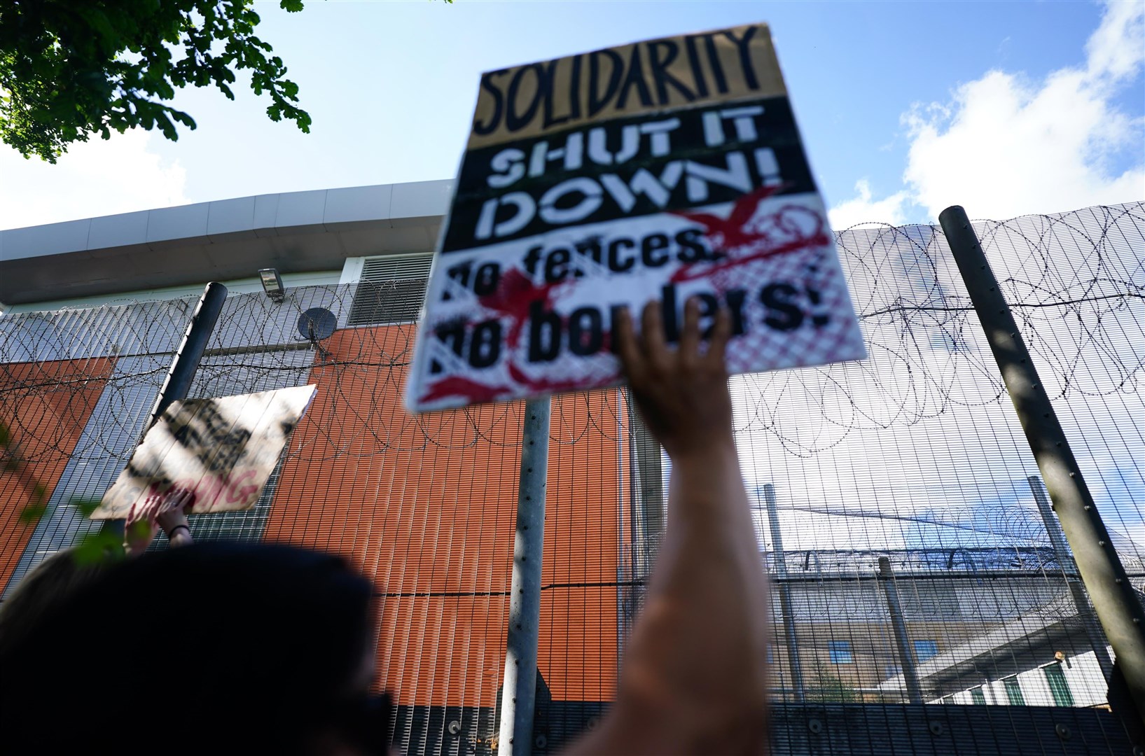 People protested outside the gates of the immigration removal centre (Victoria Jones/PA)