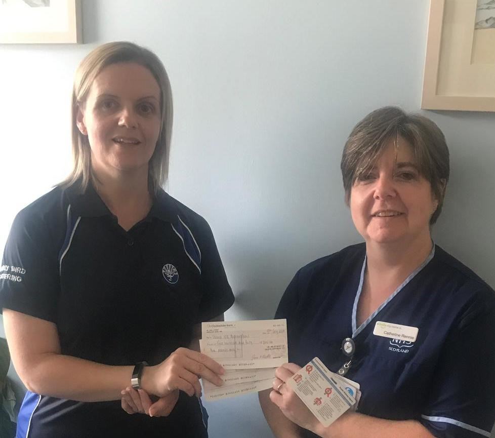 Julie McConnachie's sister Jillian Thomson hands over a cheque to Catherine Rennie from Aberdeen Royal Infirmary.