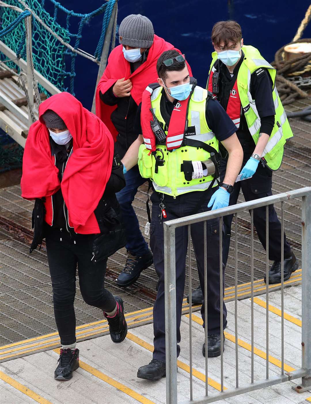 A group of people thought to be migrants are brought in to Dover, Kent, by Border Force officers following a small boat incident in the Channel (Gareth Fuller/PA)