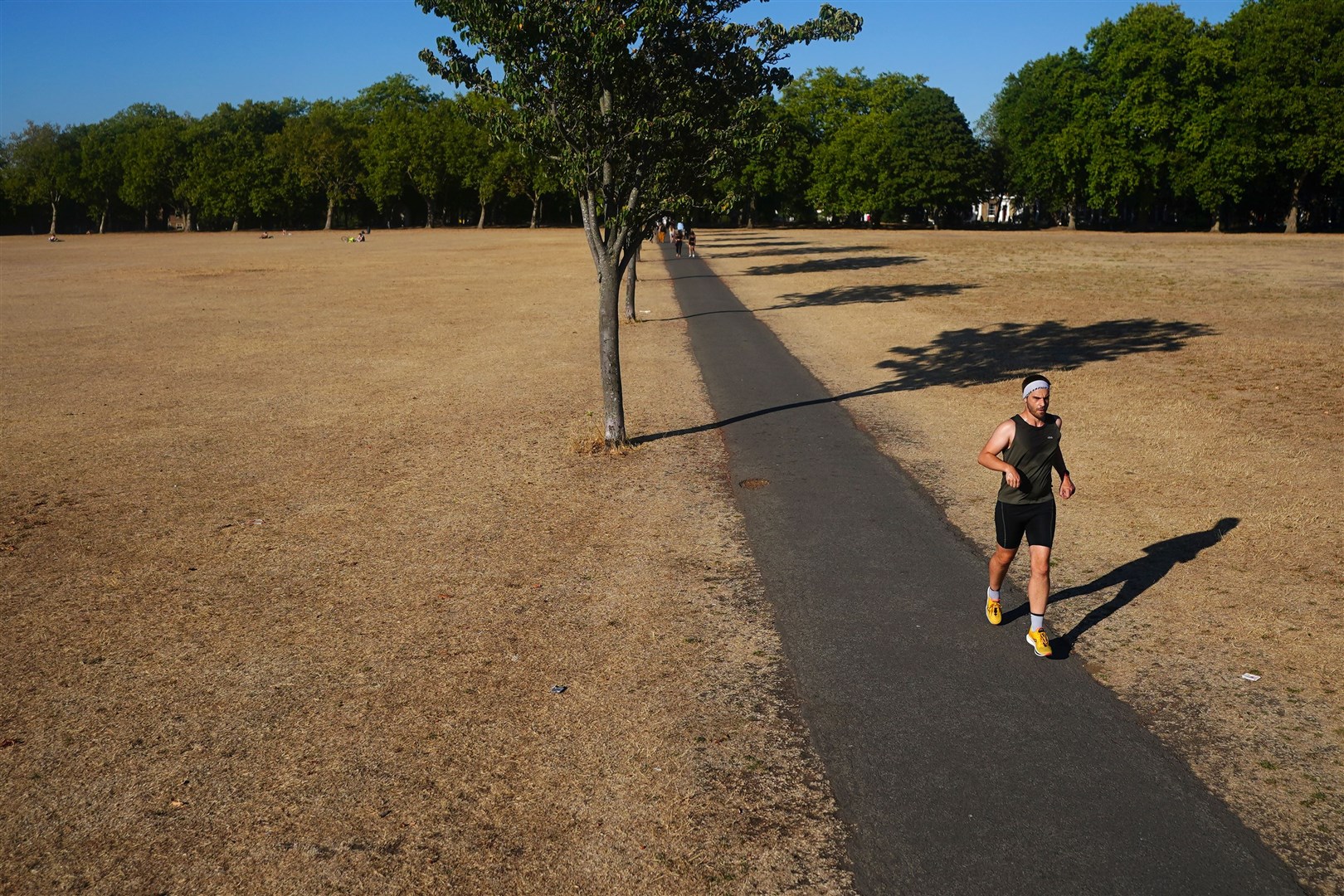 A person jogging on a path amongst dead grass in Victoria Park, east London in August (Victoria Jones/PA)