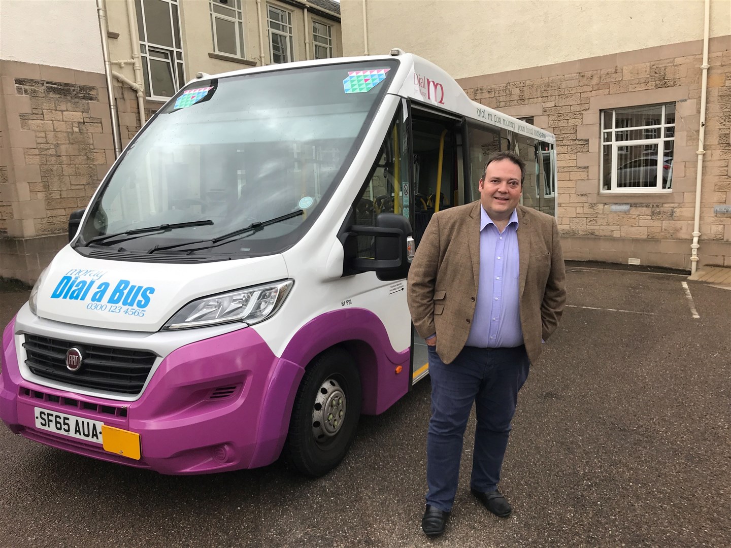 Jamie Halcro Johnston in front of a Dial-a-Bus at Moray Council headquarters in Elgin.
