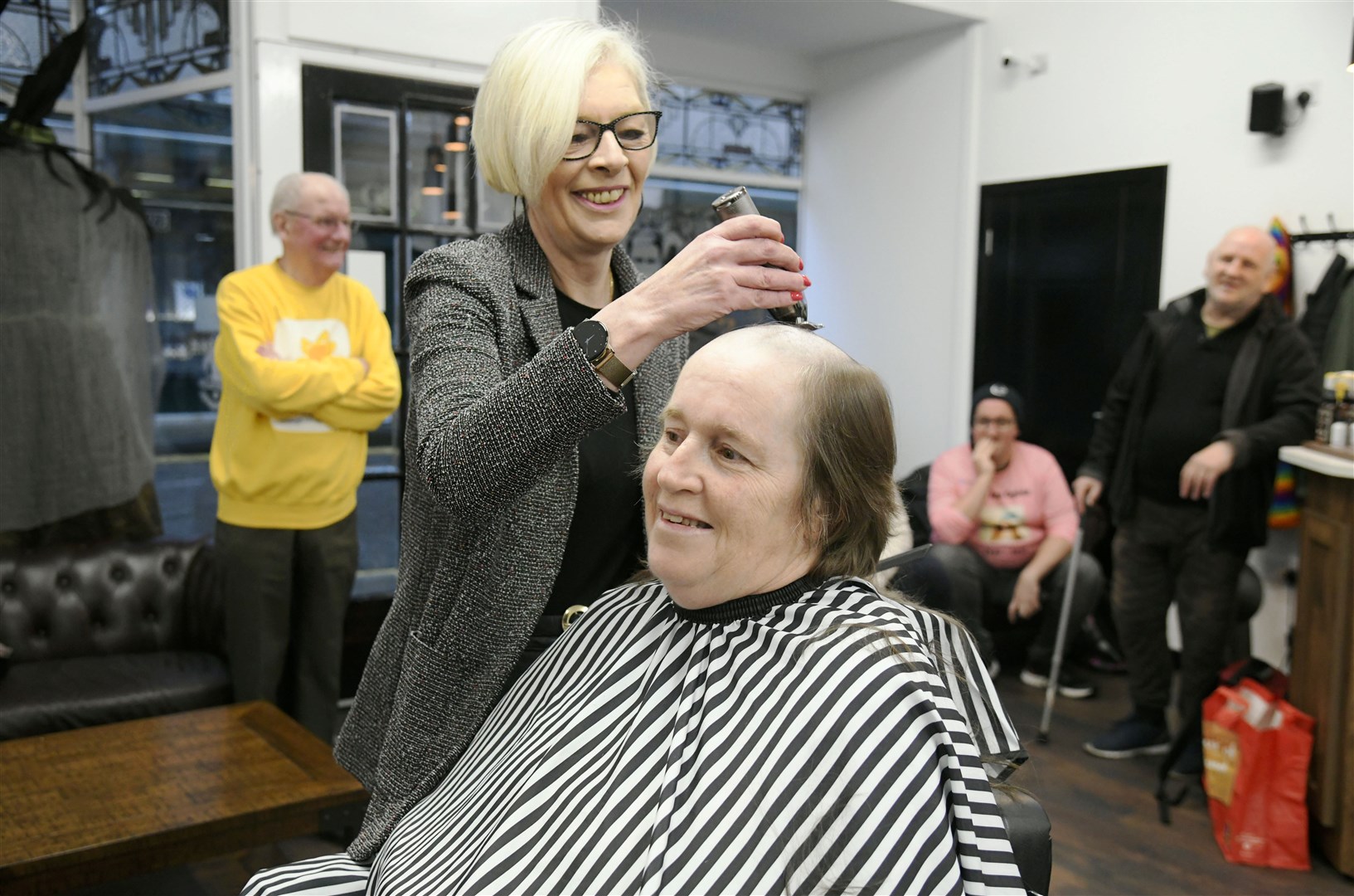Smiles all round for Linda Ogilvie during her head shave done by Kate Cutajar...K&M Barbers, Elgin...Picture: Beth Taylor.