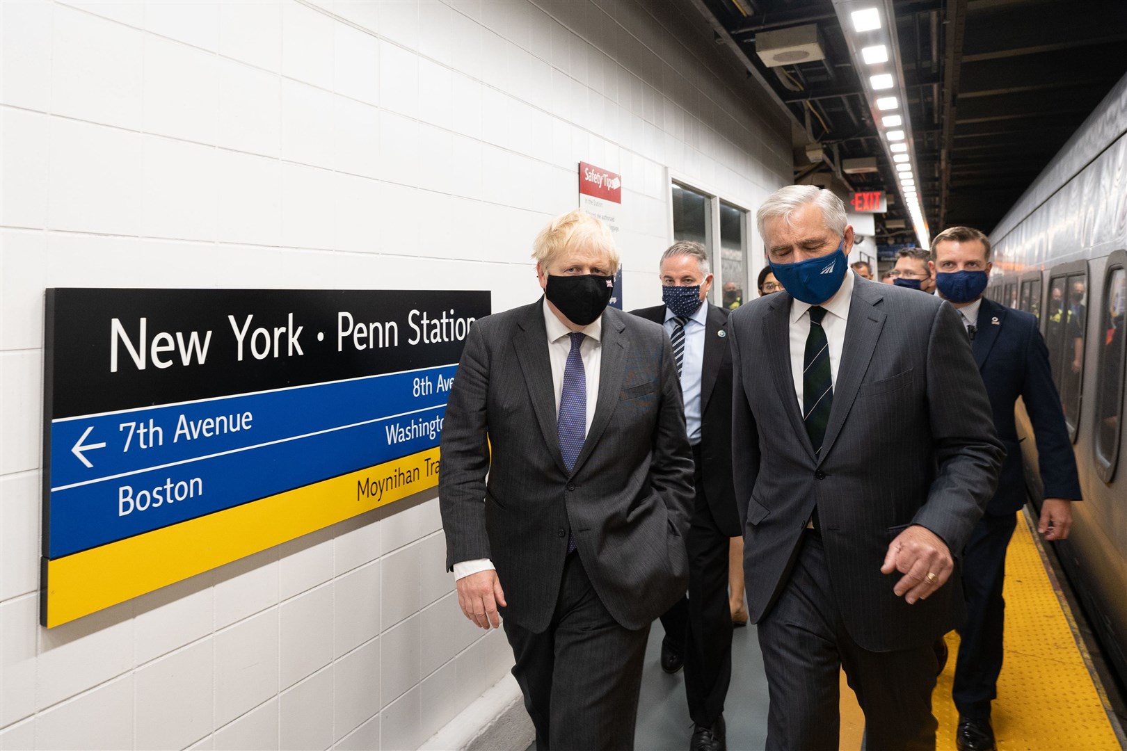 Boris Johnson (left), accompanied by Amtrak CEO William J Flynn, prepares to board a train from Penn Station in New York to Washington DC (Stefan Rousseau/PA)