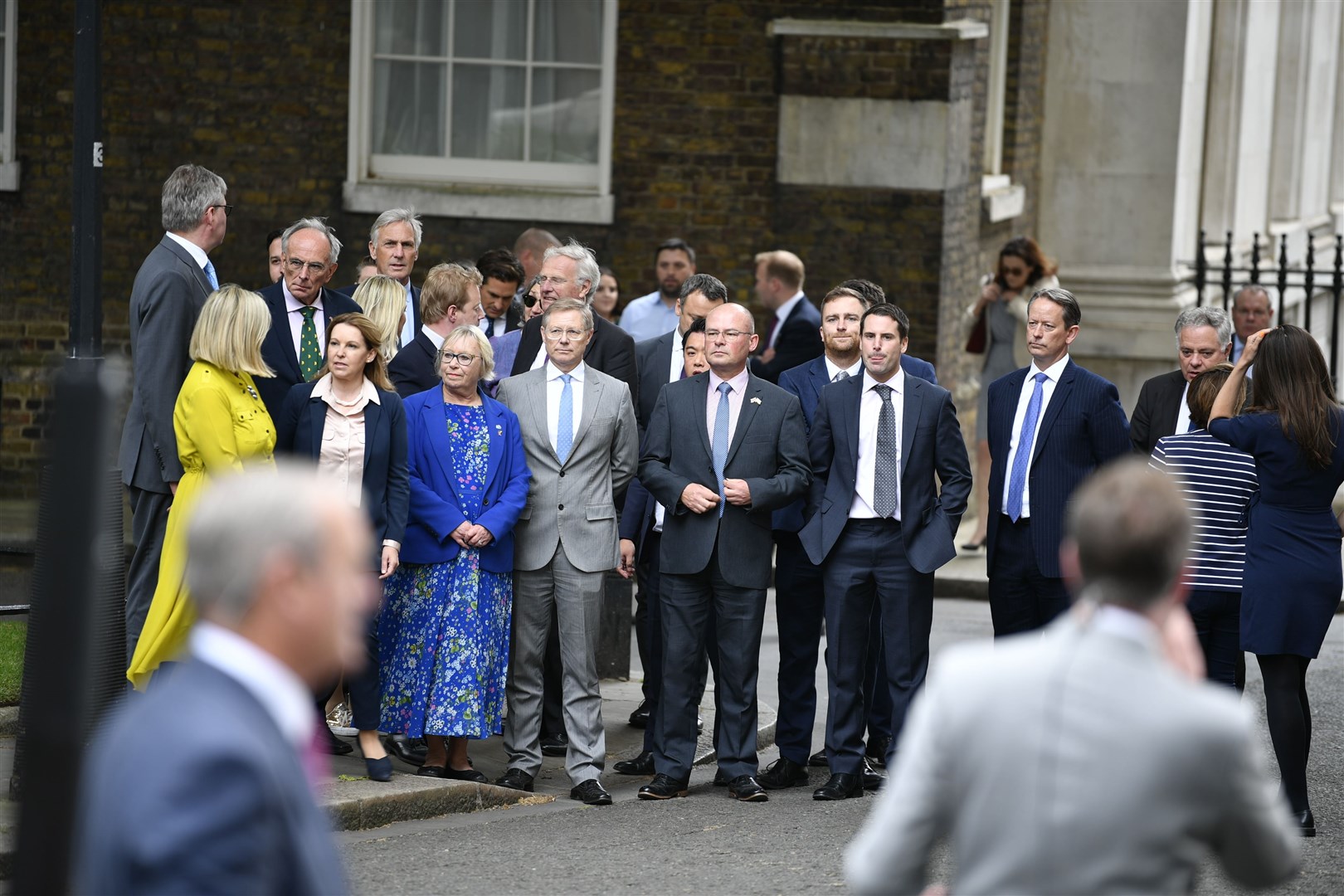 Supportive MPs watch as Prime Minister Boris Johnson reads a statement outside 10 Downing Street.