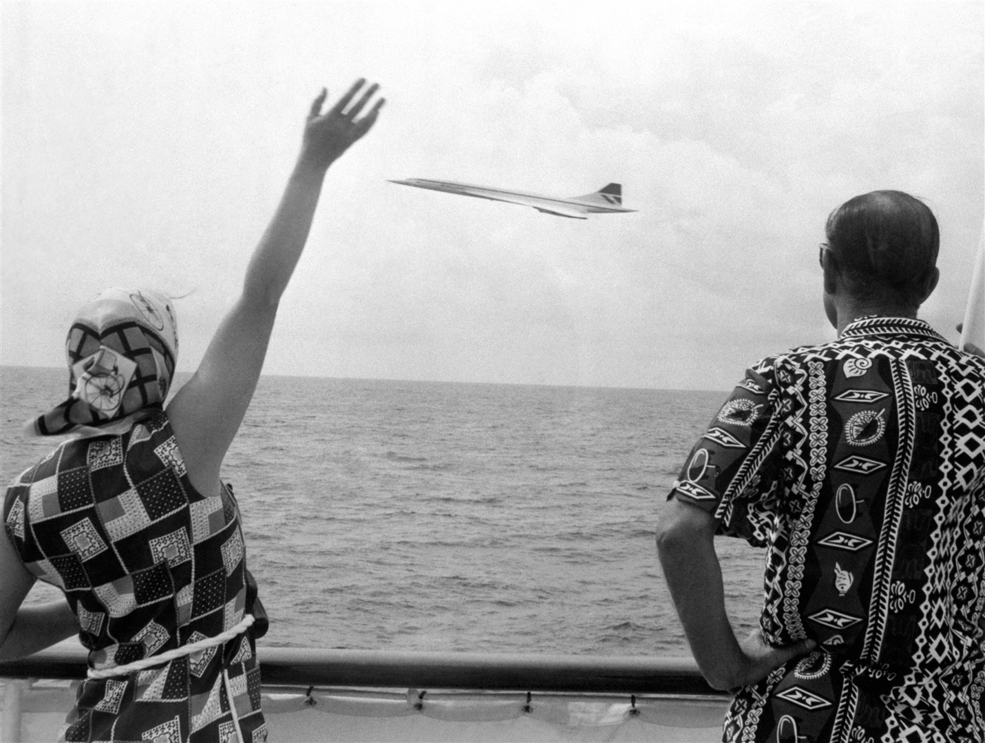 The Queen and the Duke of Edinburgh wave as Concorde flies by the Royal Yacht Britannia as the royal couple neared Barbados (PA)