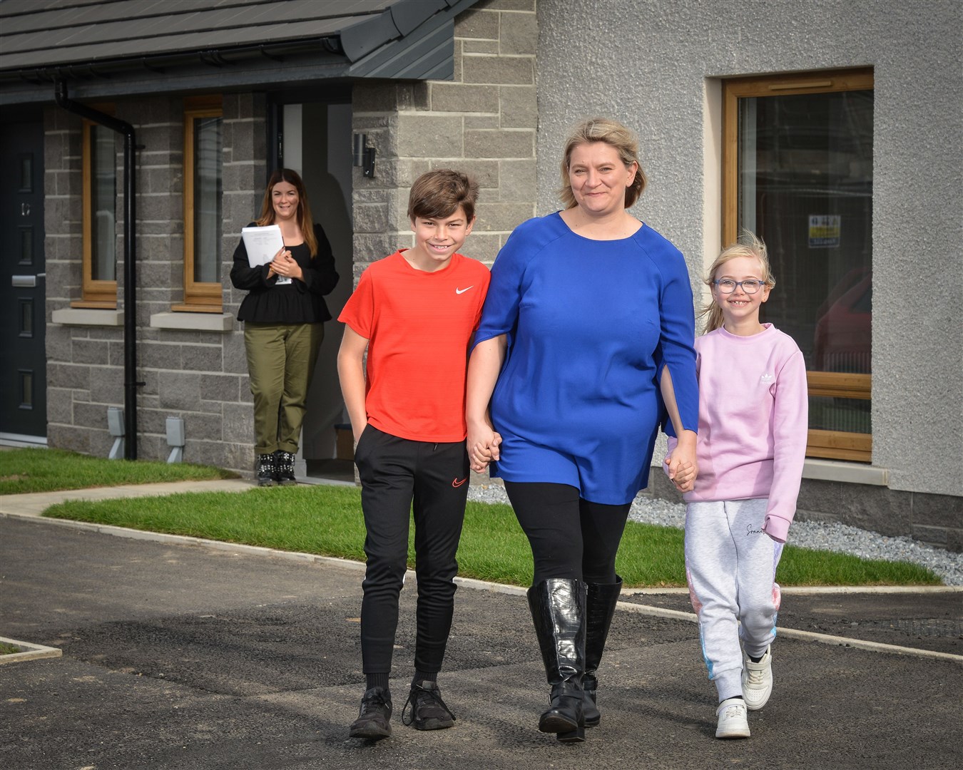 Diane Laing outside her new Osprey home on the Kinneddar Meadows estate in Lossiemouth with her children Kelvin and April. Handing over the keys was Osprey housing officer Rhiannon Garbutt (left).