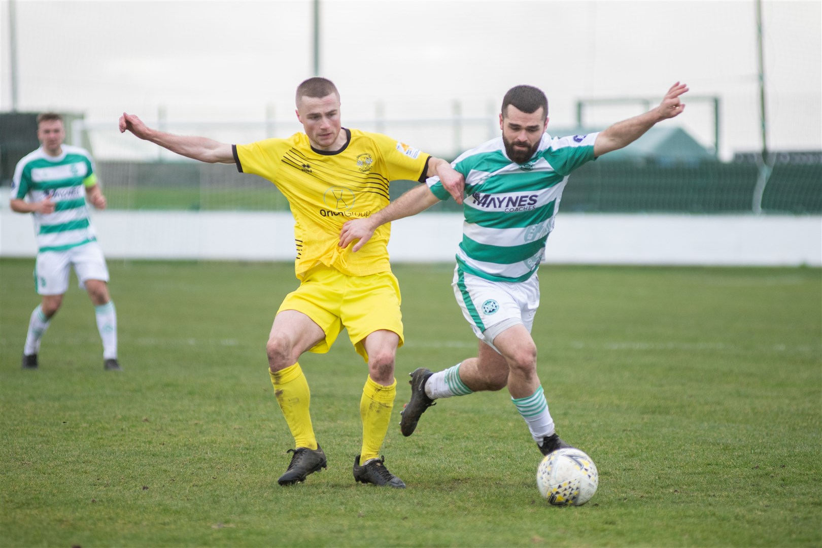 Clachnacuddin's Rorie Macleod links arms with Buckie's Andy MacAskill as the chase a ball down at Victoria Park. ..Buckie Thistle FC (5) vs Clachnacuddin FC (0) - Highland Football League 22/23 - Victoria Park, Buckie 25/02/23...Picture: Daniel Forsyth..