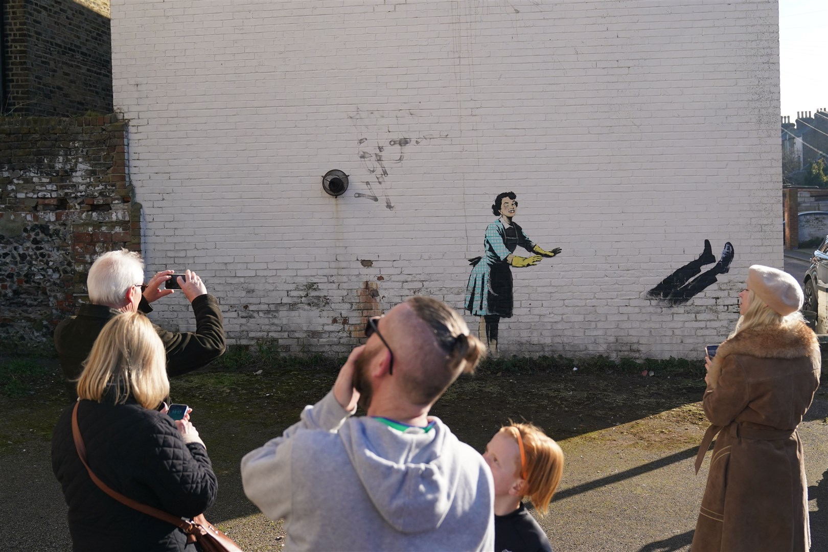 Sightseers check out the artwork following the first removal by the local council (Gareth Fuller/PA)