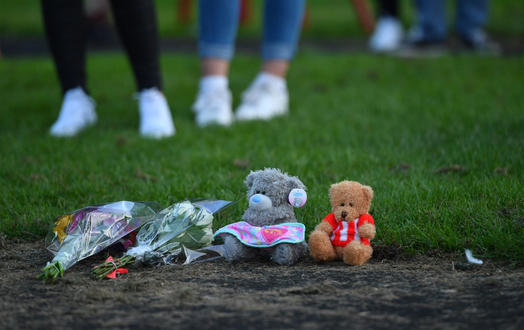 Flowers and soft toys are seen at the vigil (Anthony Devlin/PA)