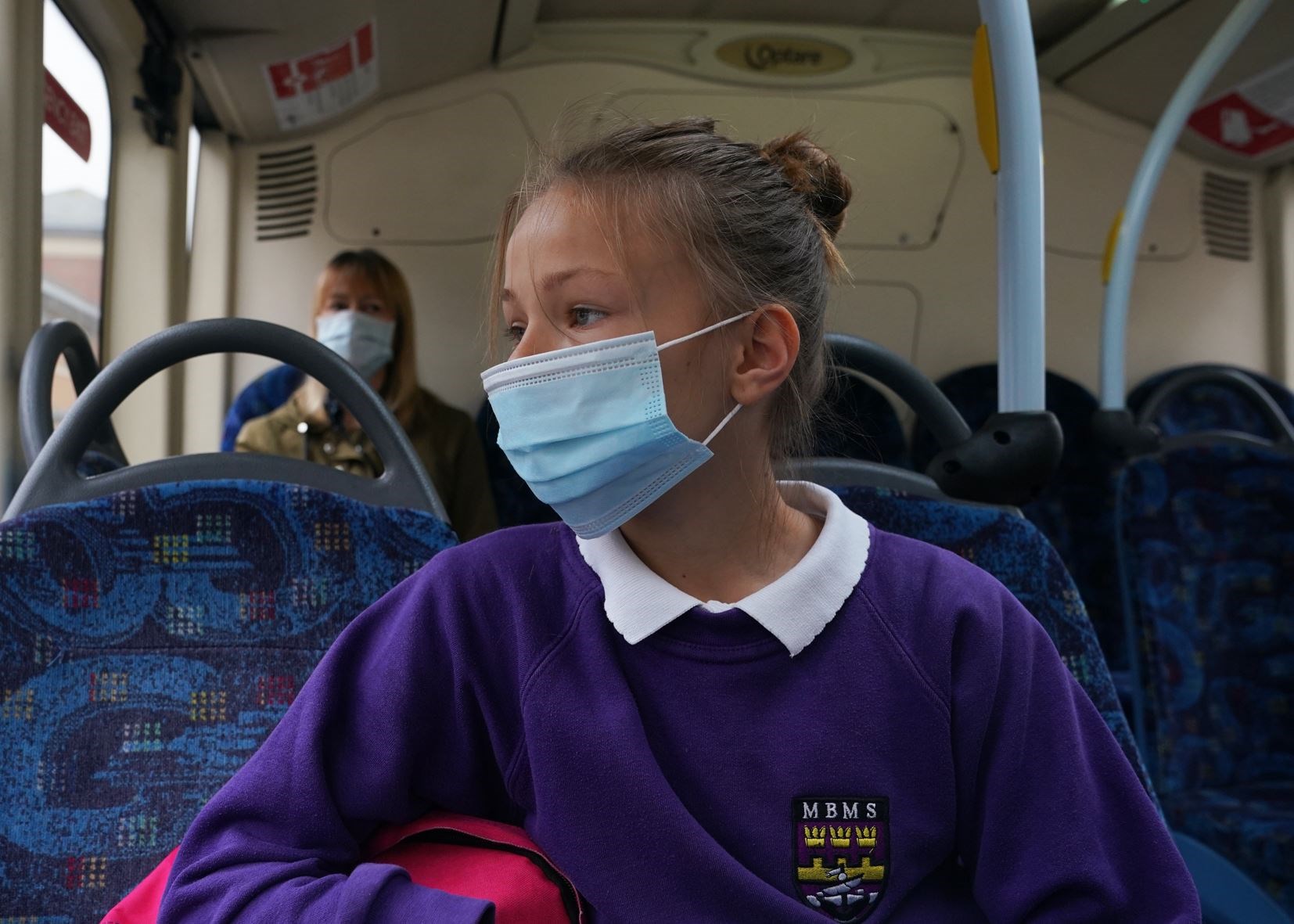 A school pupil wearing a face mask on a bus (Owen Humphreys/PA)
