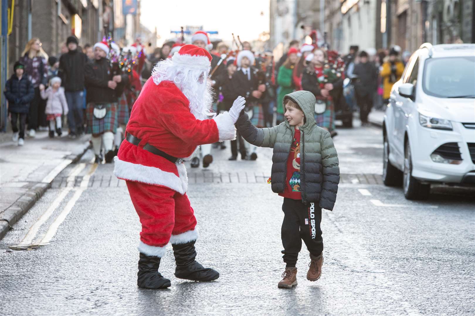 A high five from young Corey Moir as Santa leads the Strathisla Pipe Band down Mid Street. Picture: Daniel Forsyth