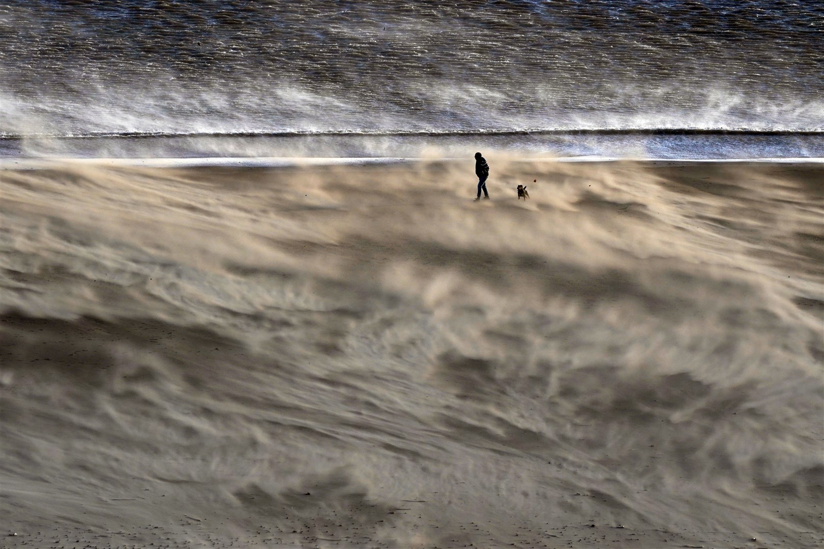 A person on a windy Tynemouth beach on the North East coast as Storm Malik swept in in January (Owen Humphreys/PA)