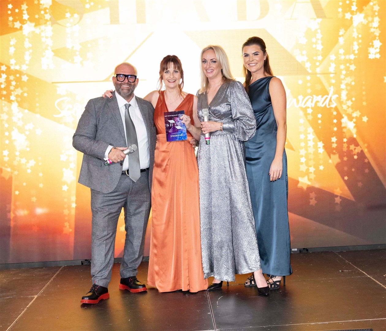 Kerry, in the orange dress, with her award for Best Massage at the SHABAs last month.