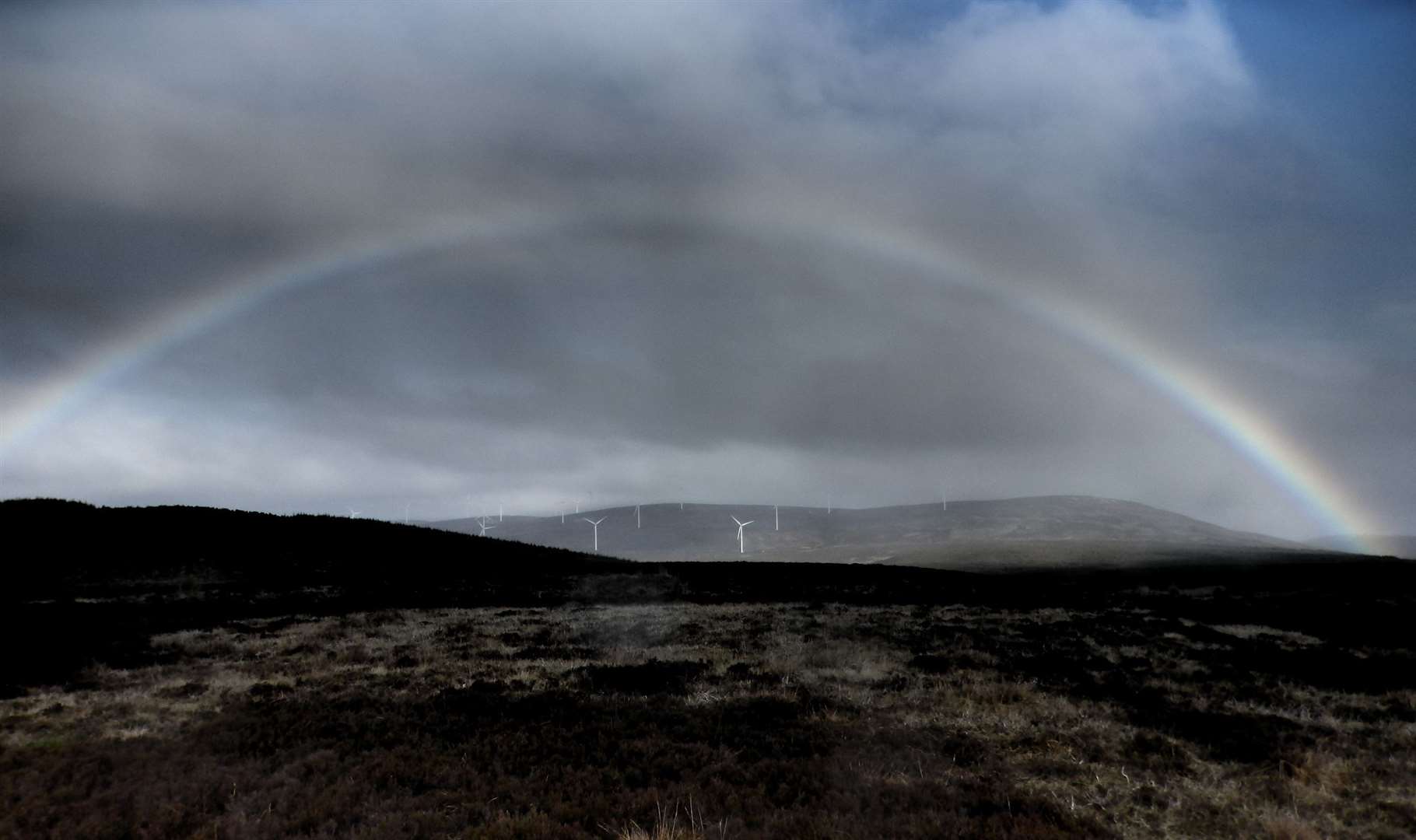 A rainbow arcs over the 59-turbine Dorenell wind farm.