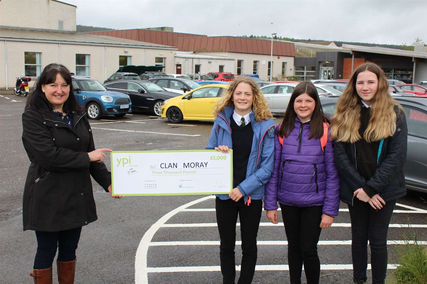 Hannah Jupp, Neve Cruickshank and Amelia Lockhart hand a cheque for £3000 to Julie Muir, local service co-ordinator for Clan Cancer Support Moray. Picture: Milne's High