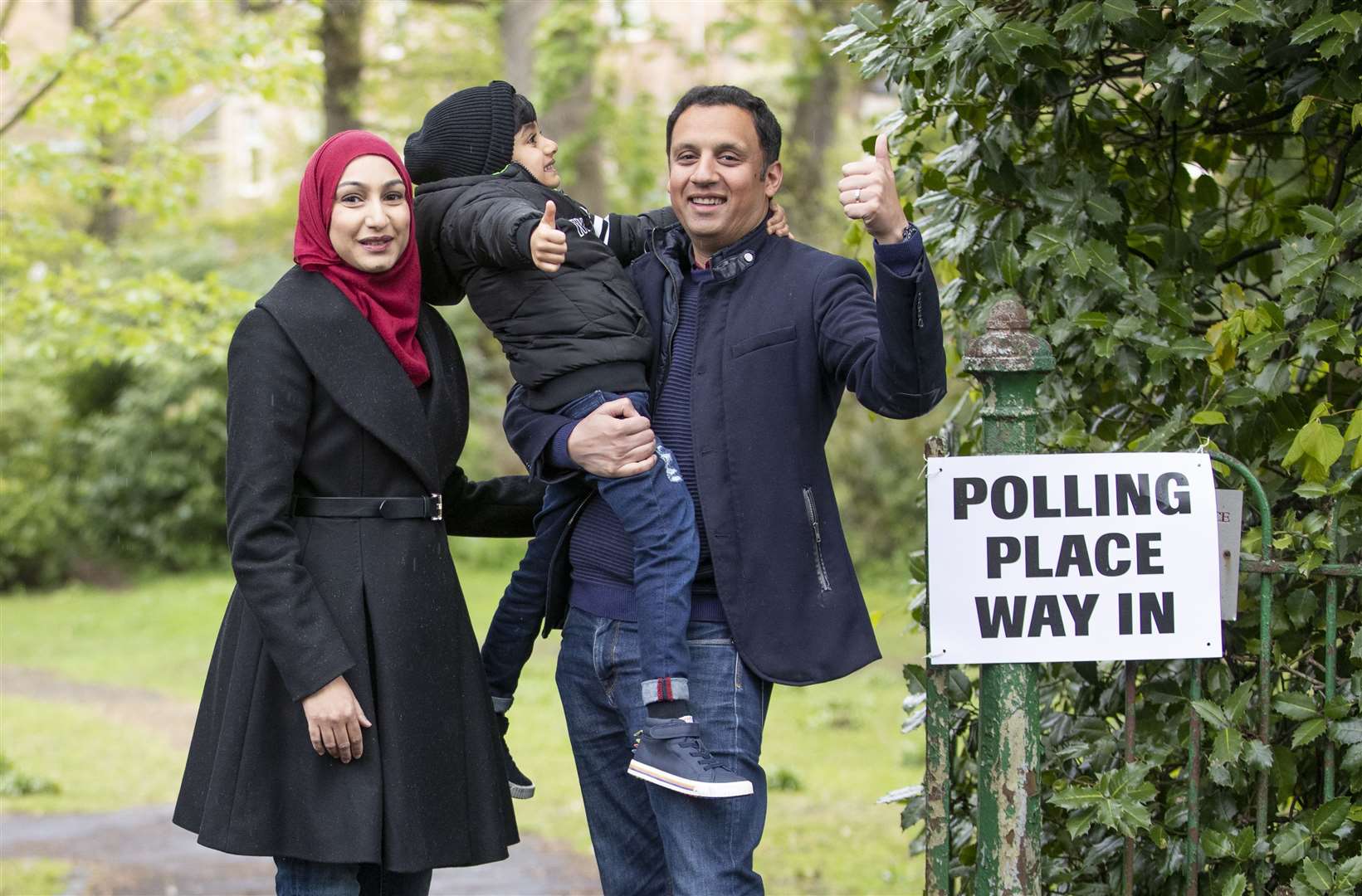 Scottish Labour leader Anas Sarwar, with his wife Furheen and son Ailyan, arrives at Pollokshields Burgh Hall in Glasgow to deliver his vote (Jane Barlow/PA)